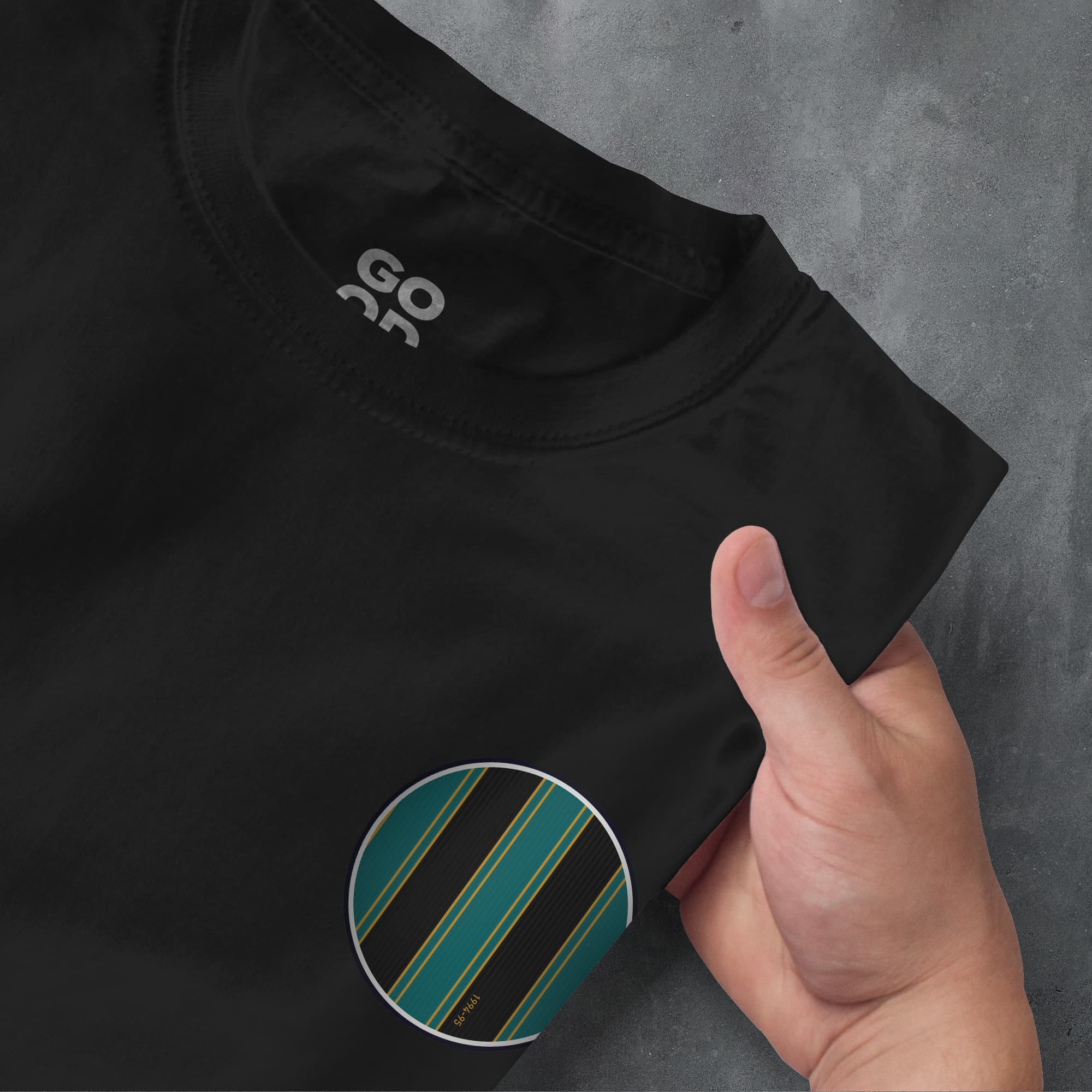 a person pointing at a black shirt with a green stripe on it