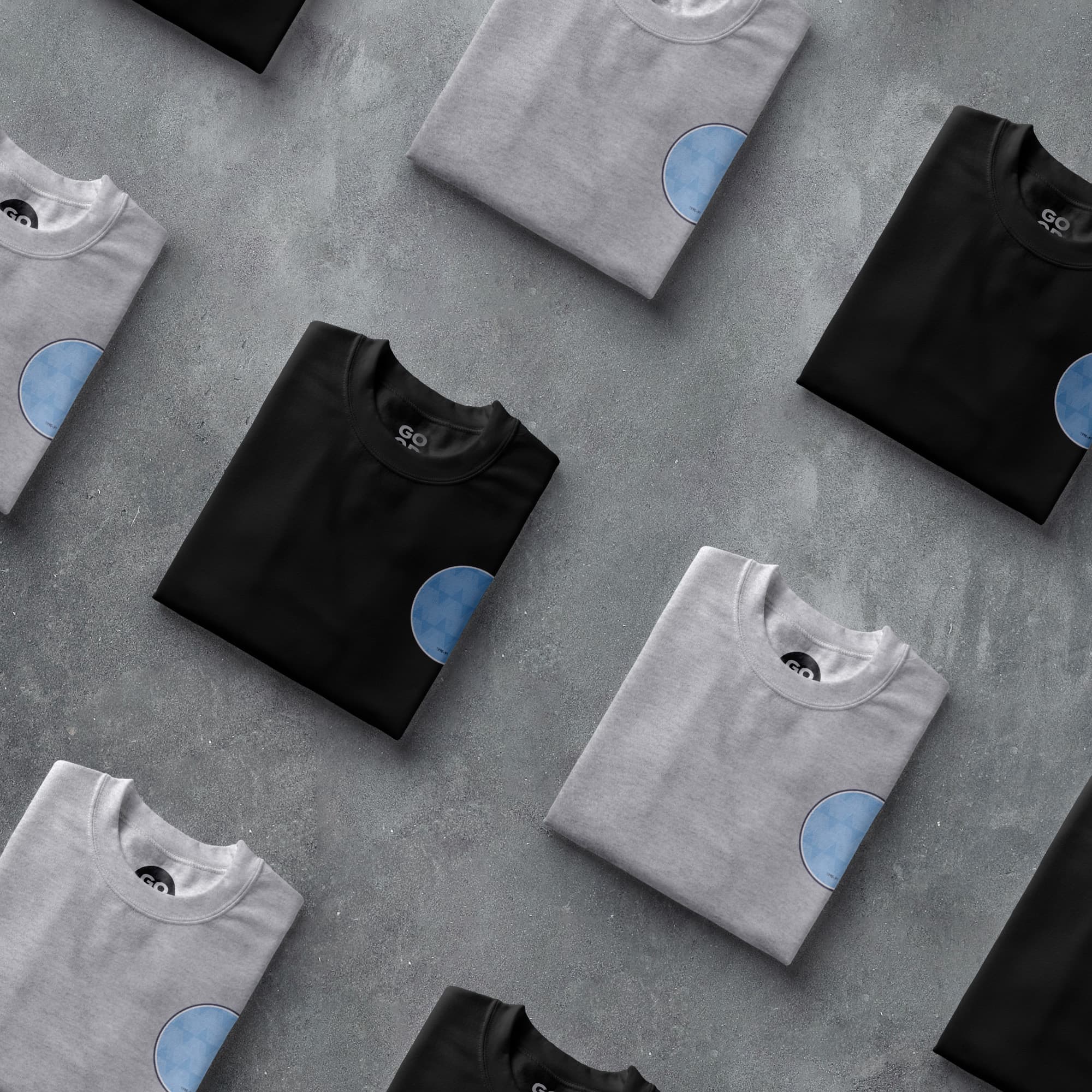 a group of t - shirts sitting on top of a cement floor