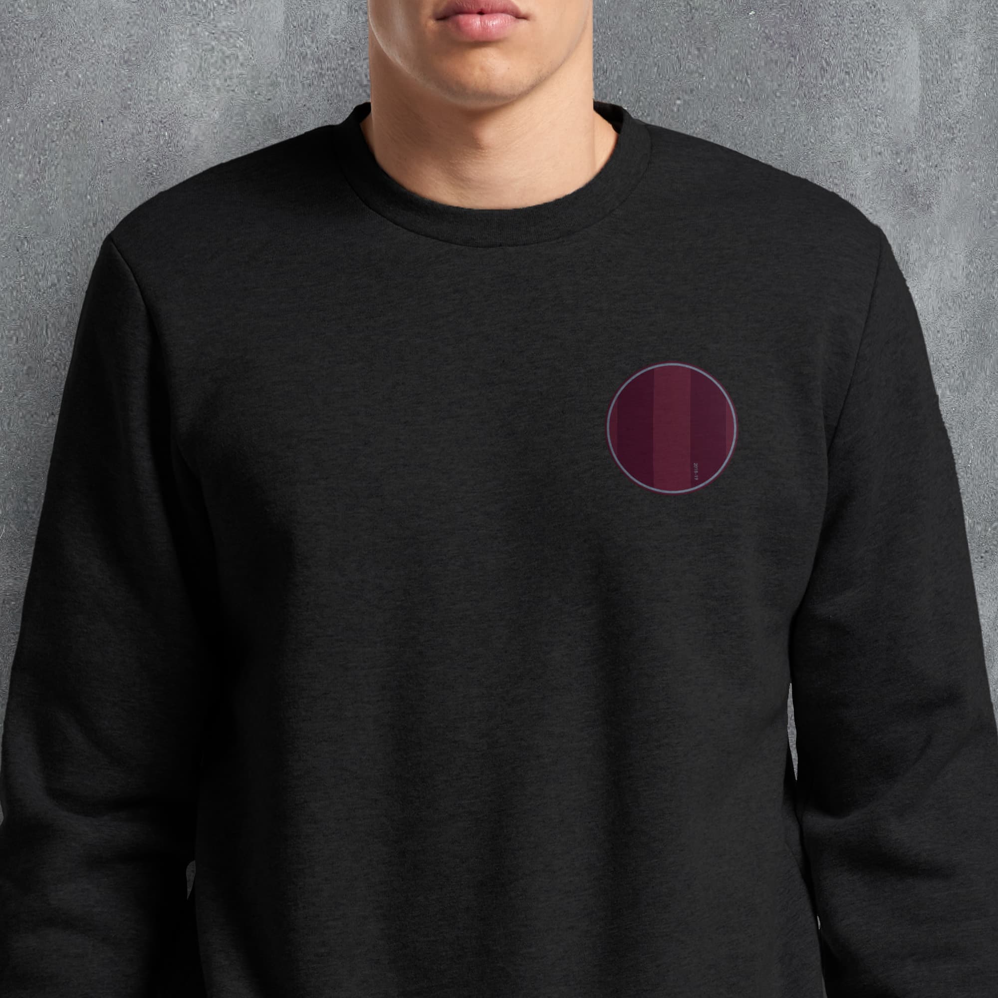 a man wearing a black sweatshirt with a purple circle on it