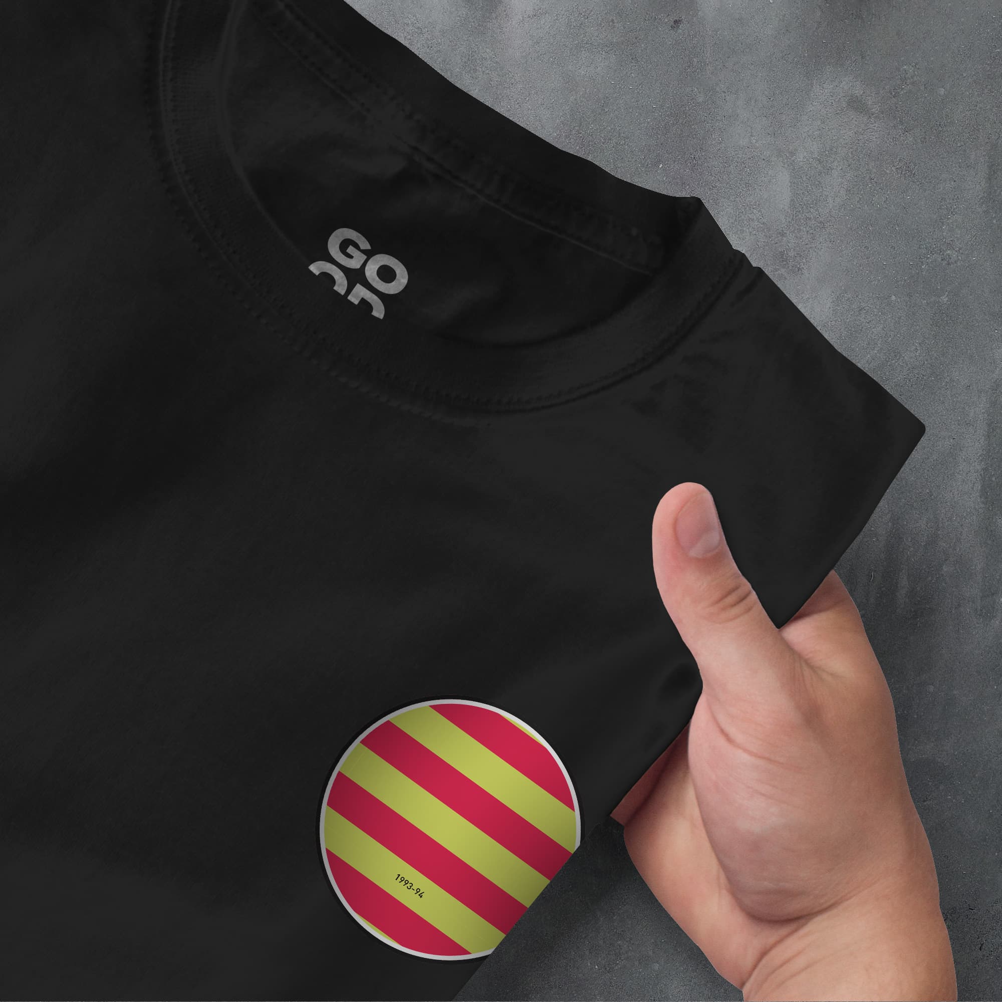 a person holding a black shirt with a red and green stripe on it