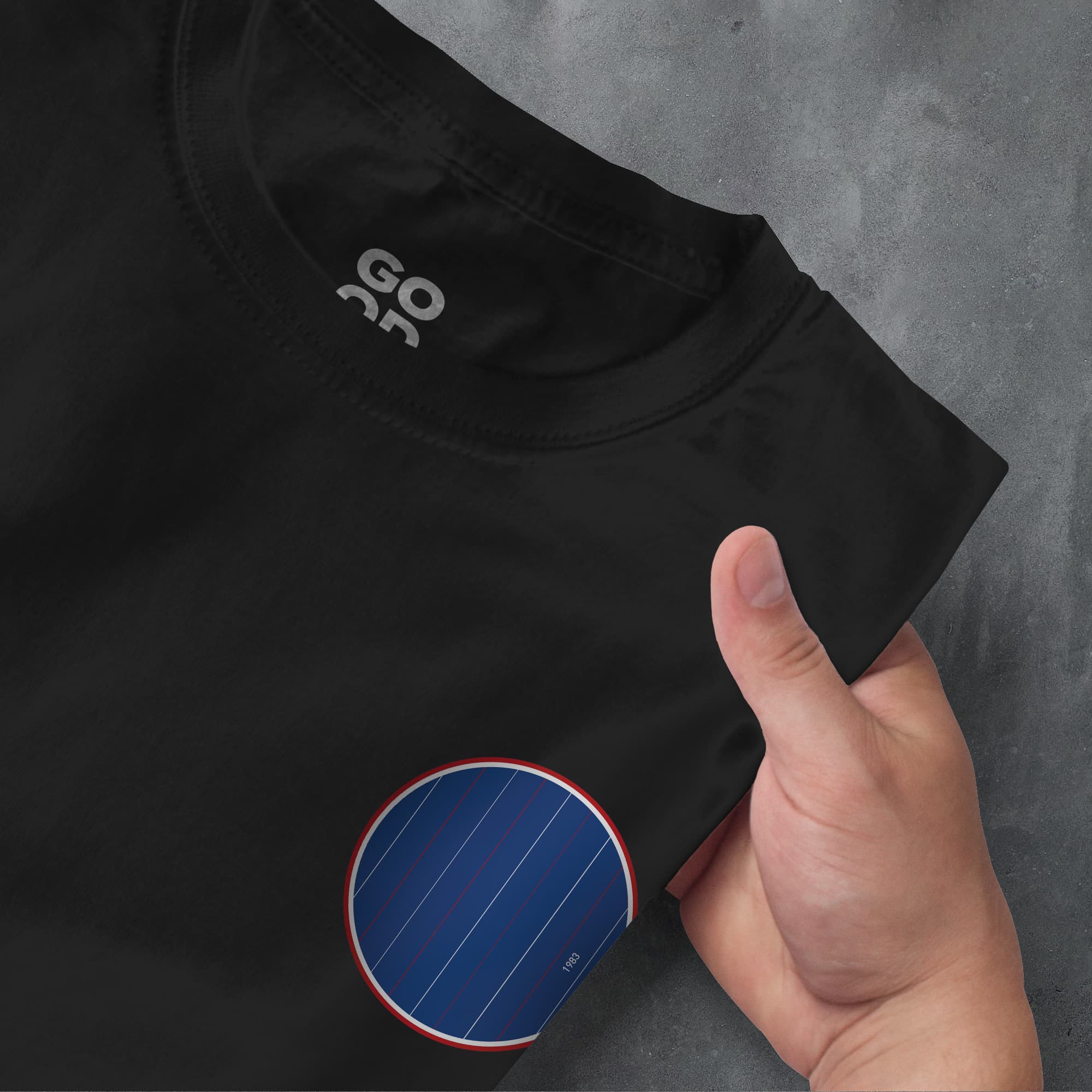a person pointing at a black shirt with a blue circle on it