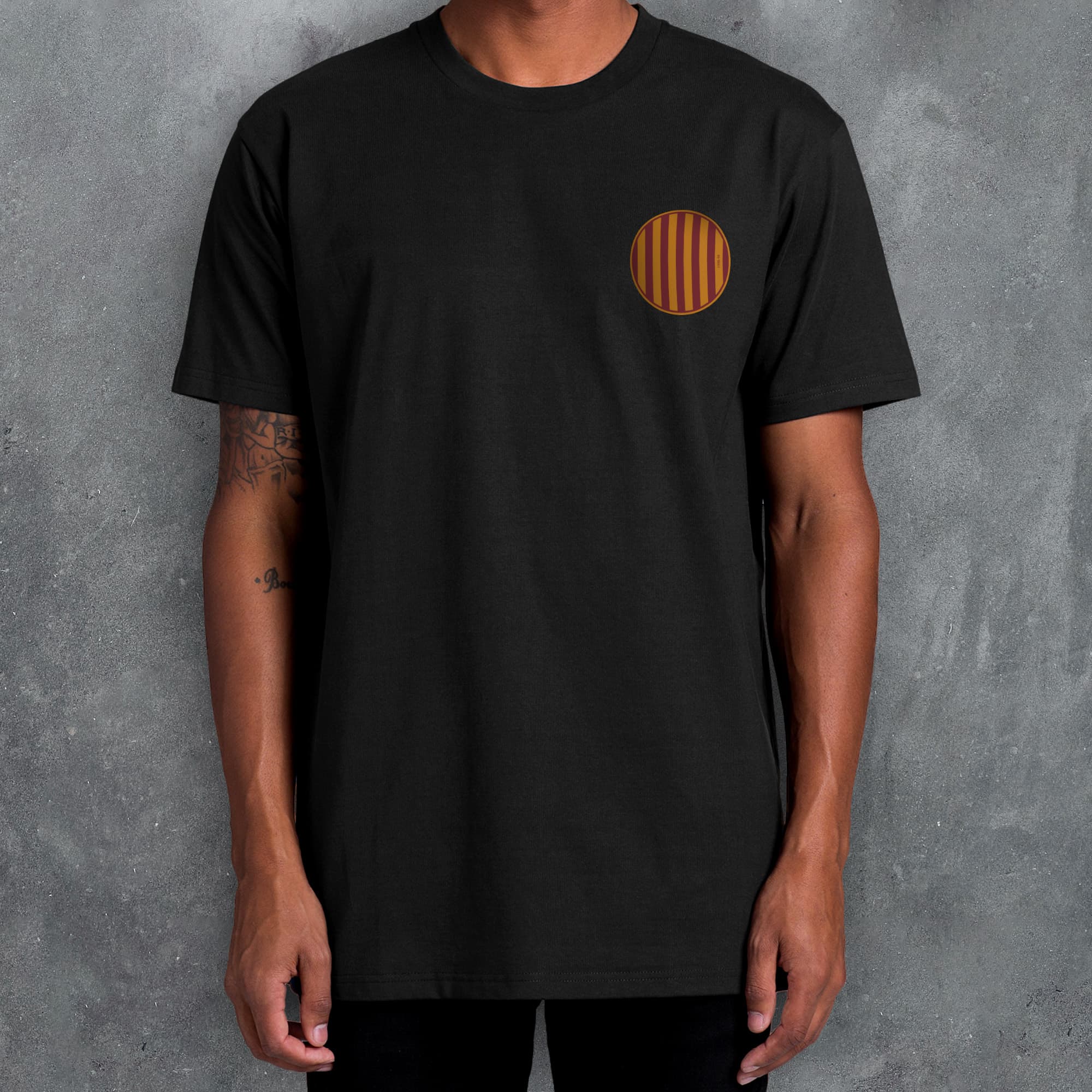 a man wearing a black t - shirt with an orange circle on it