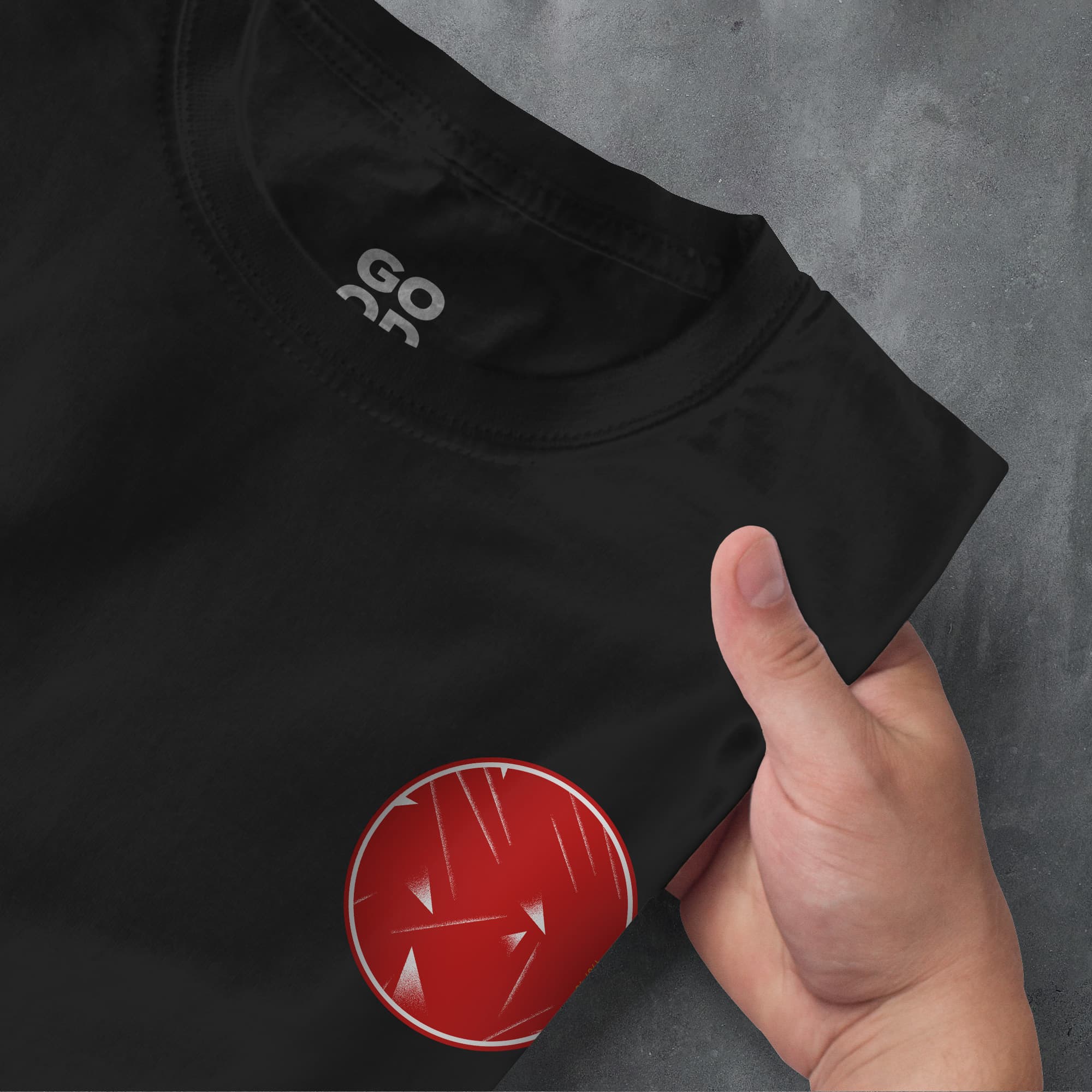 a person pointing at a red button on a black shirt
