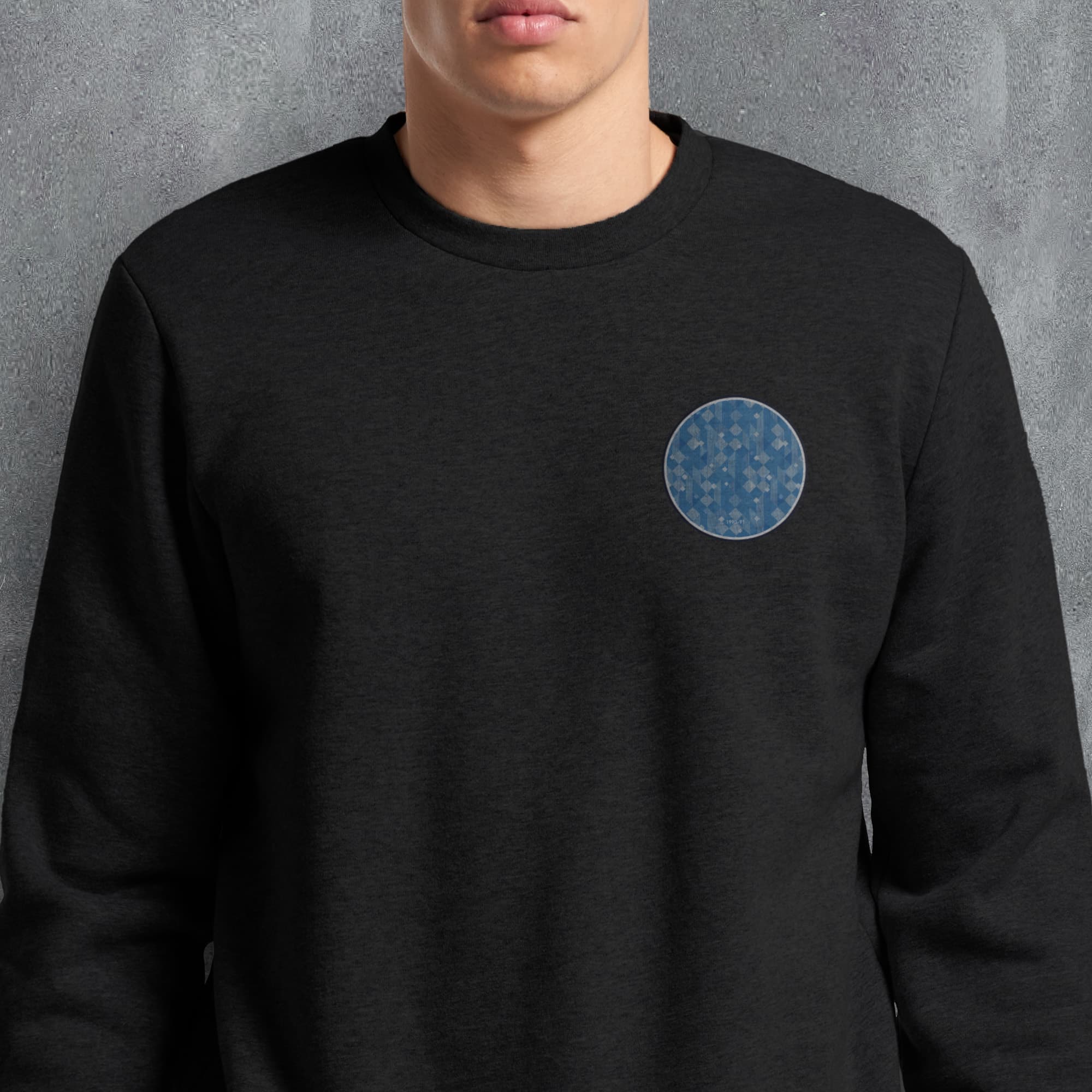 a man wearing a black sweatshirt with a blue circle on it