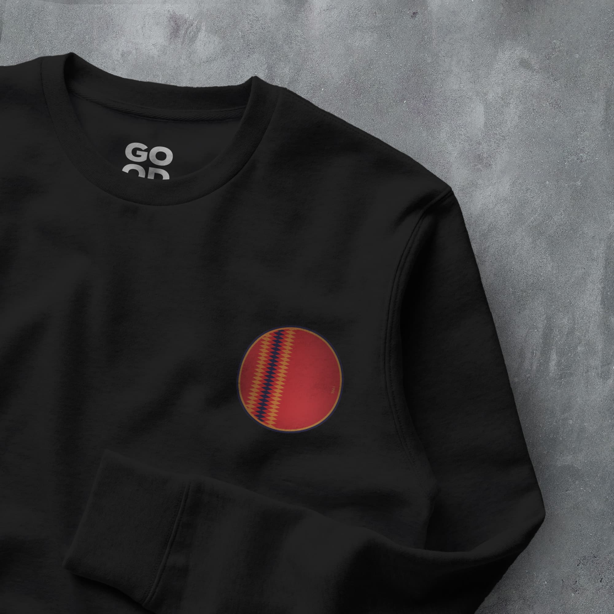 a black sweatshirt with a red and yellow ball on it