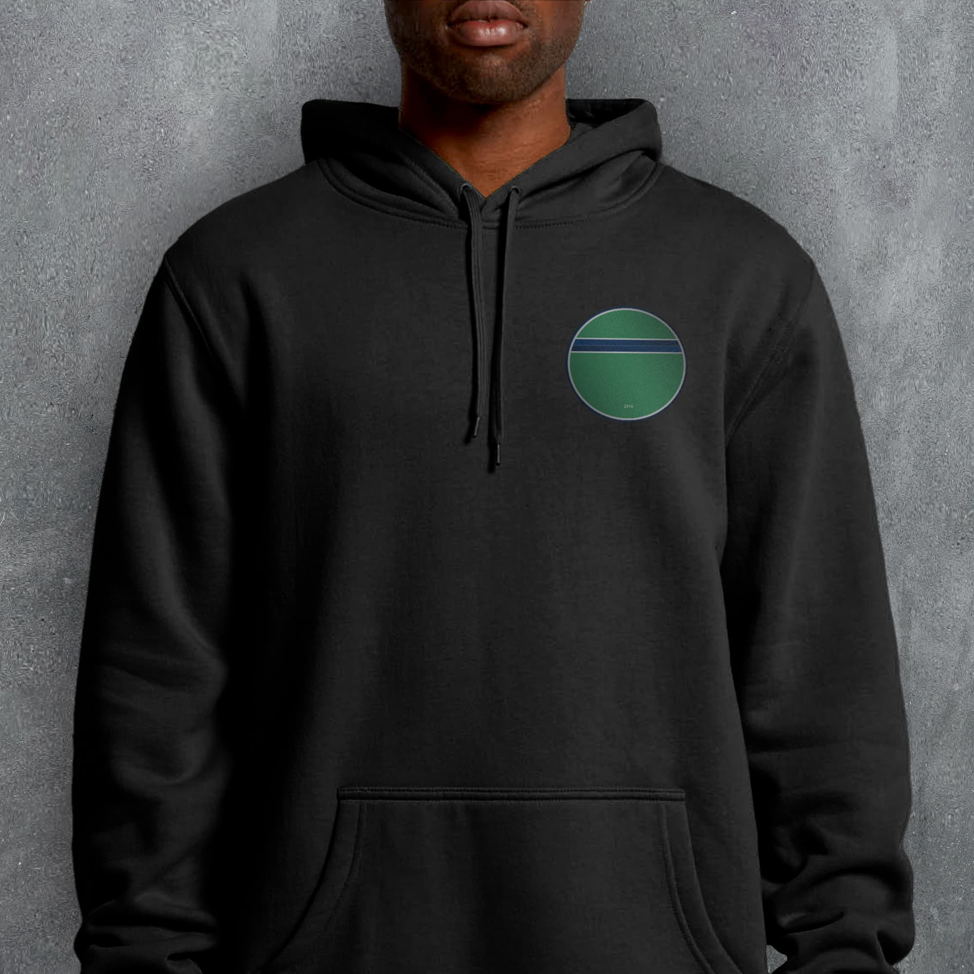 a man wearing a black hoodie with a green circle on it