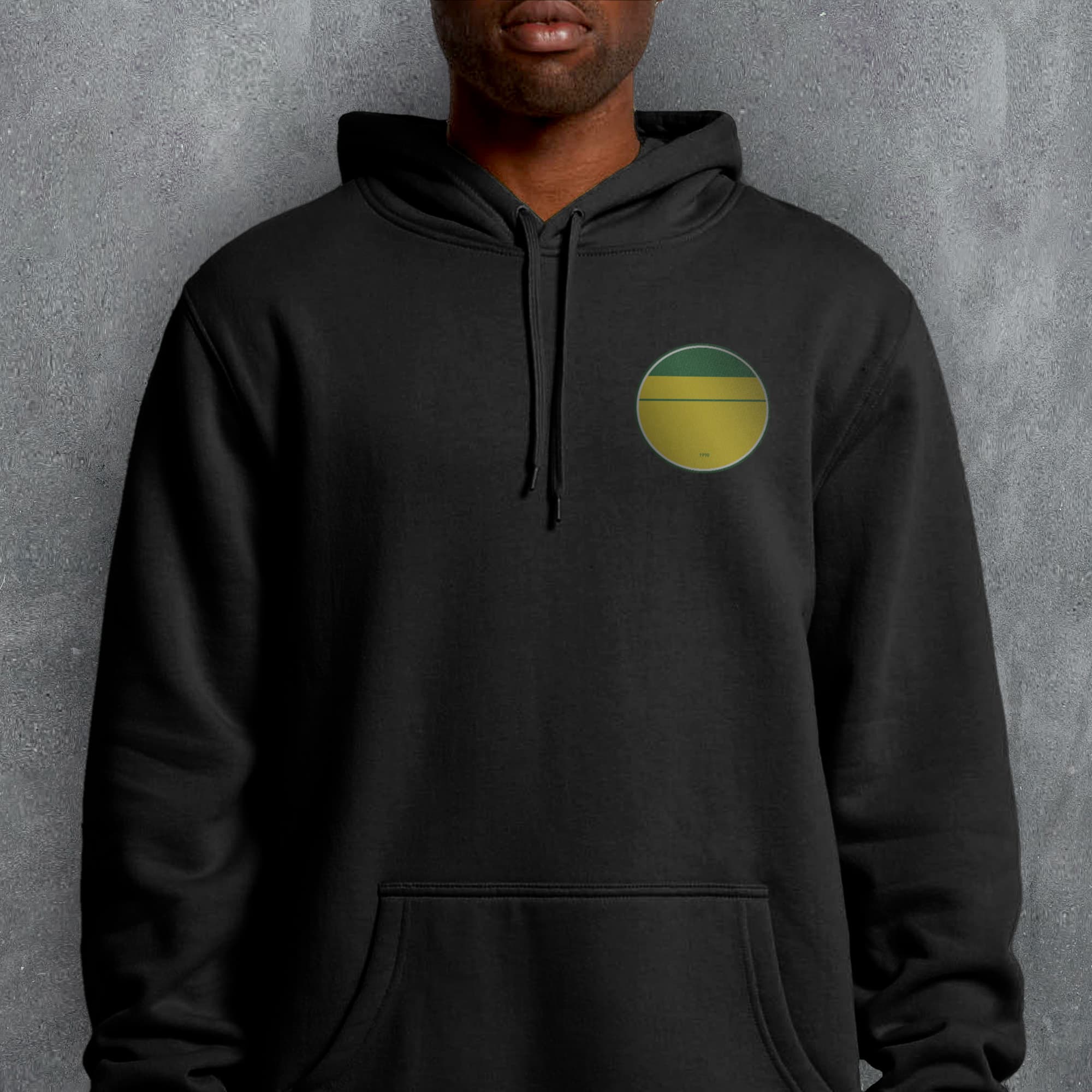 a man wearing a black hoodie with a yellow and green circle on it