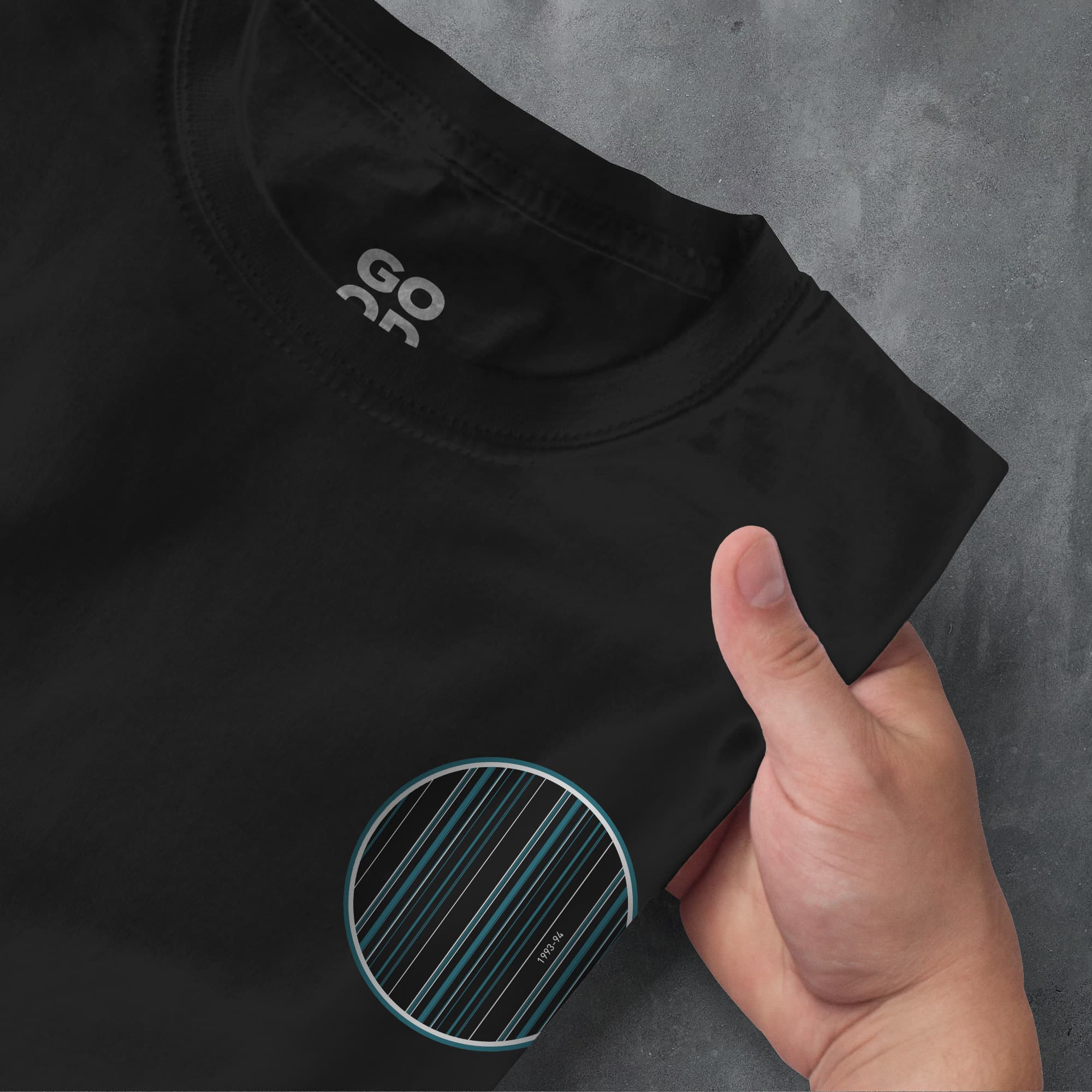 a hand pointing at a black shirt with a blue stripe on it