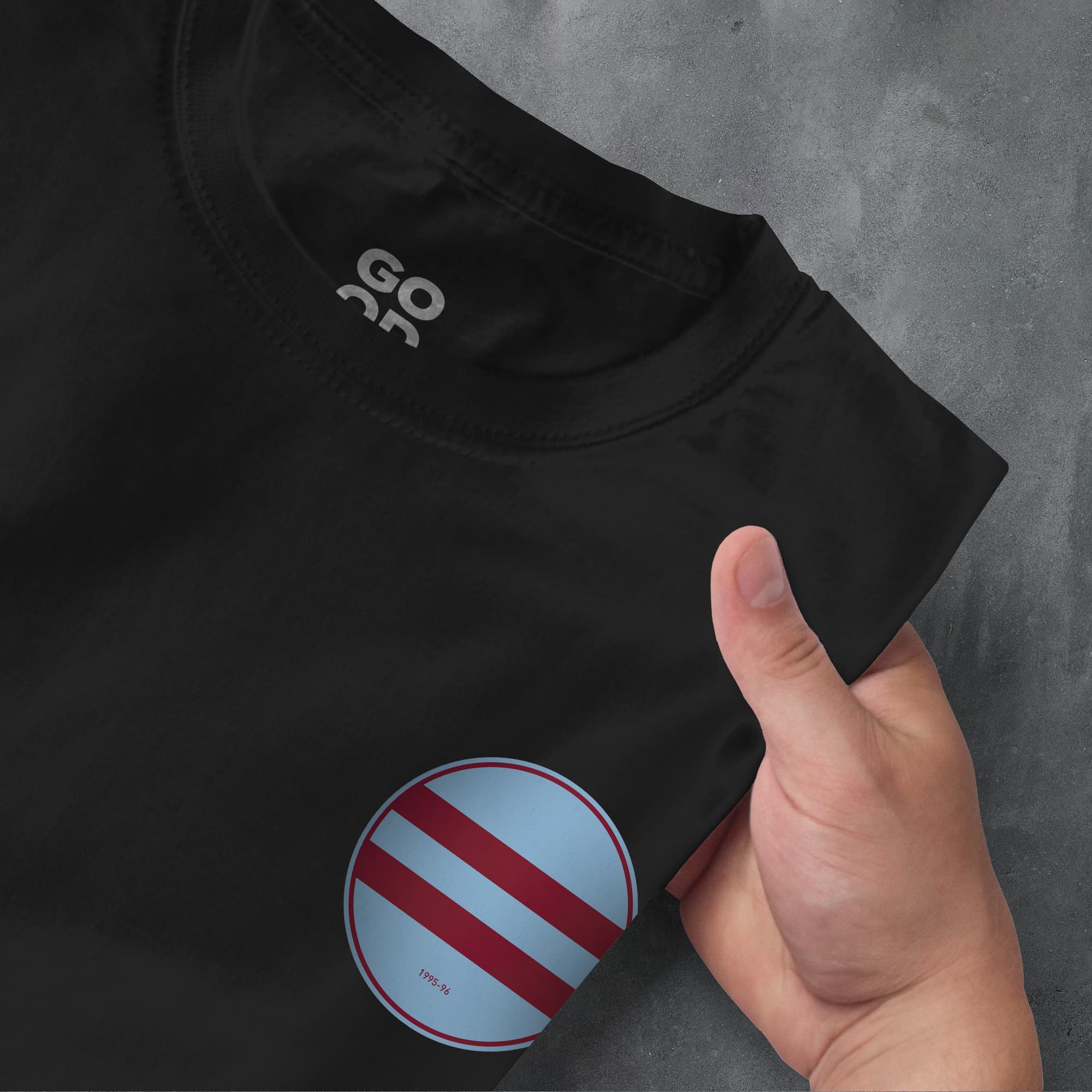 a person holding a black shirt with a red and blue stripe on it