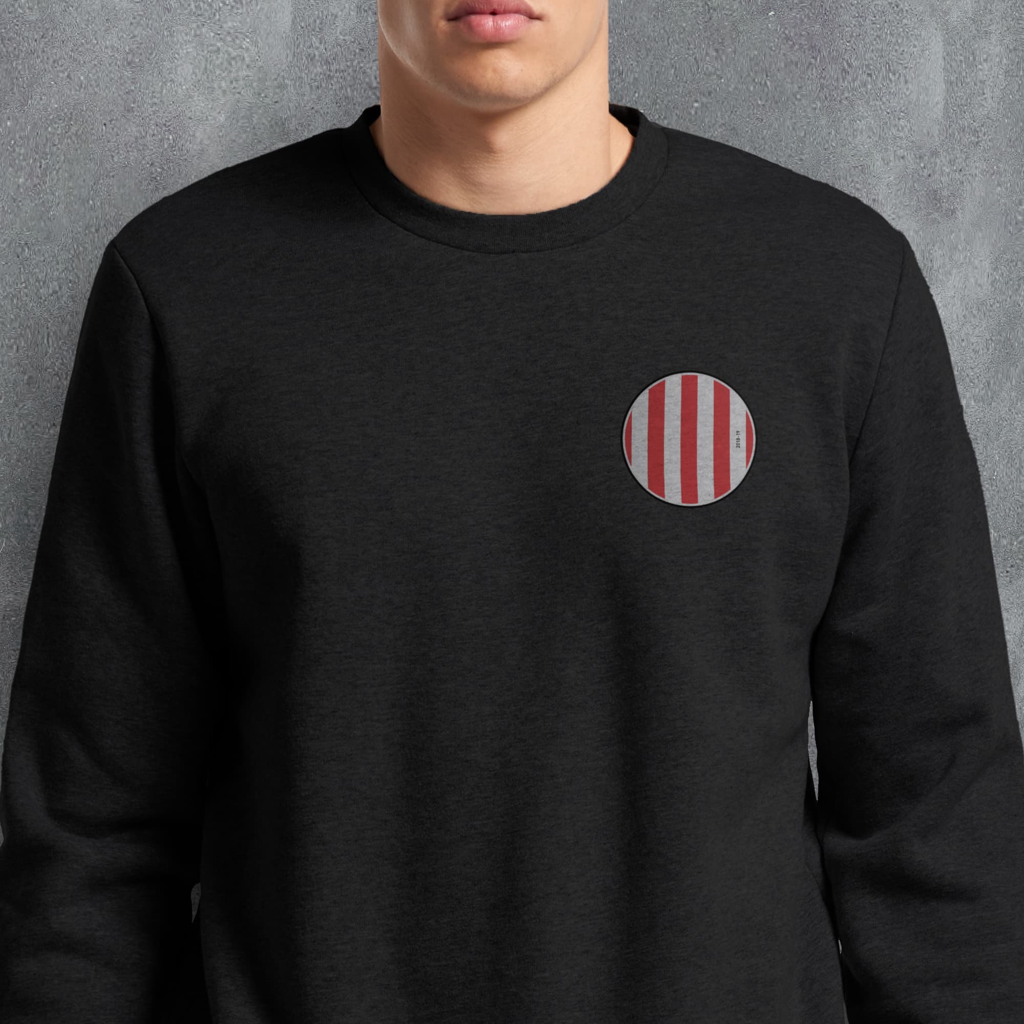 a man wearing a black sweatshirt with a red and white striped pocket