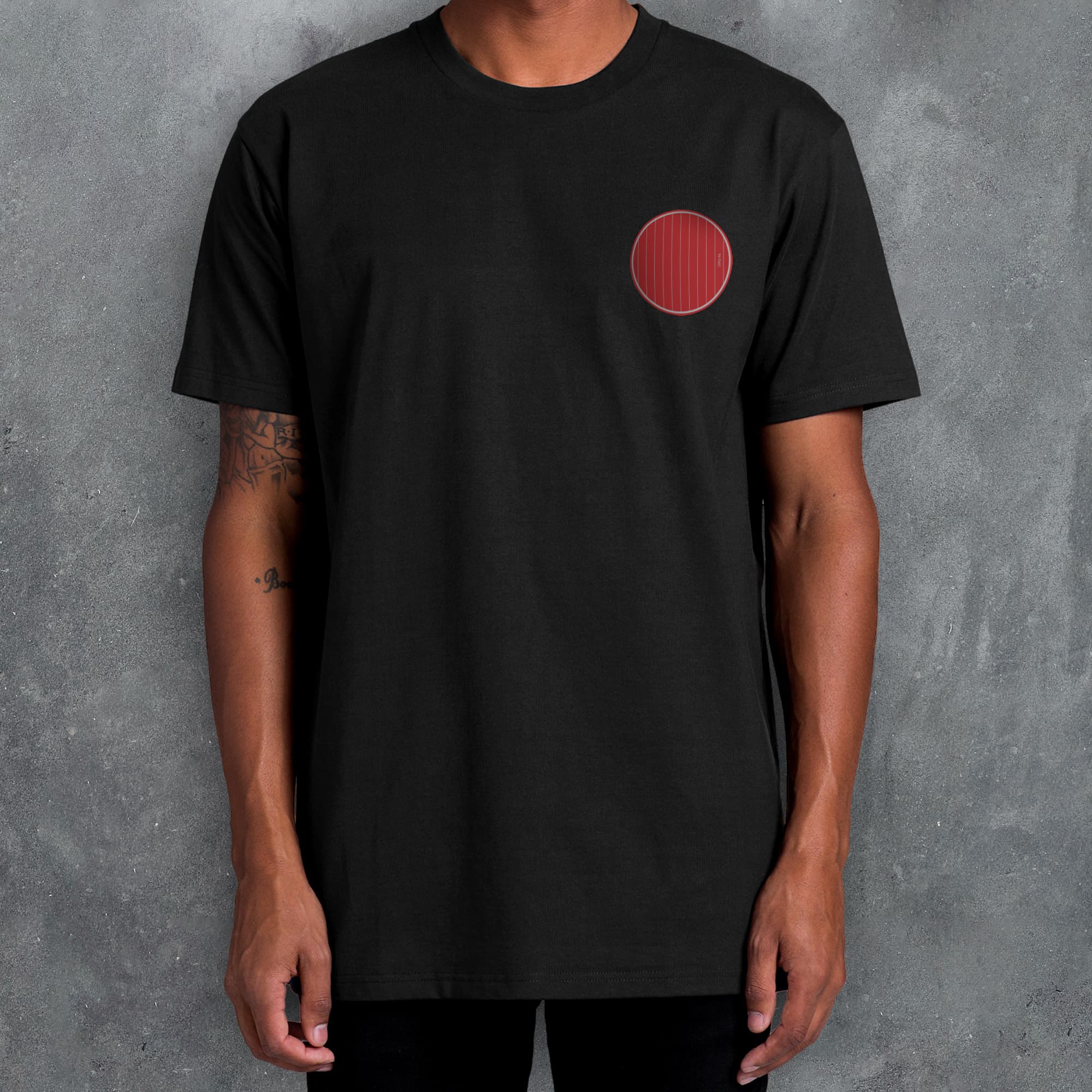 a man wearing a black shirt with a red circle on it