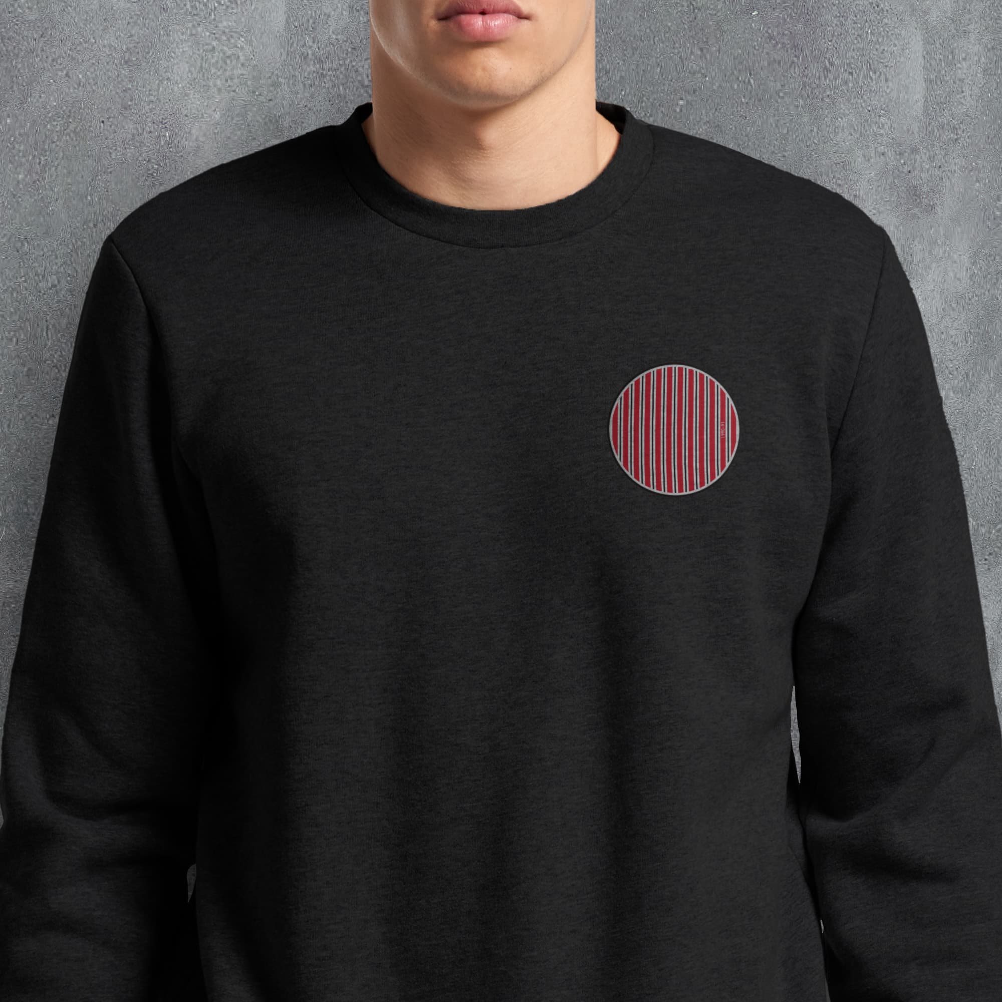a man wearing a black sweatshirt with a red circle on it