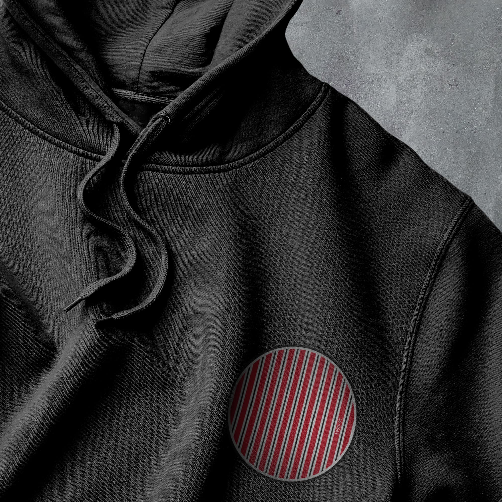 a close up of a black hoodie with a red stripe on it