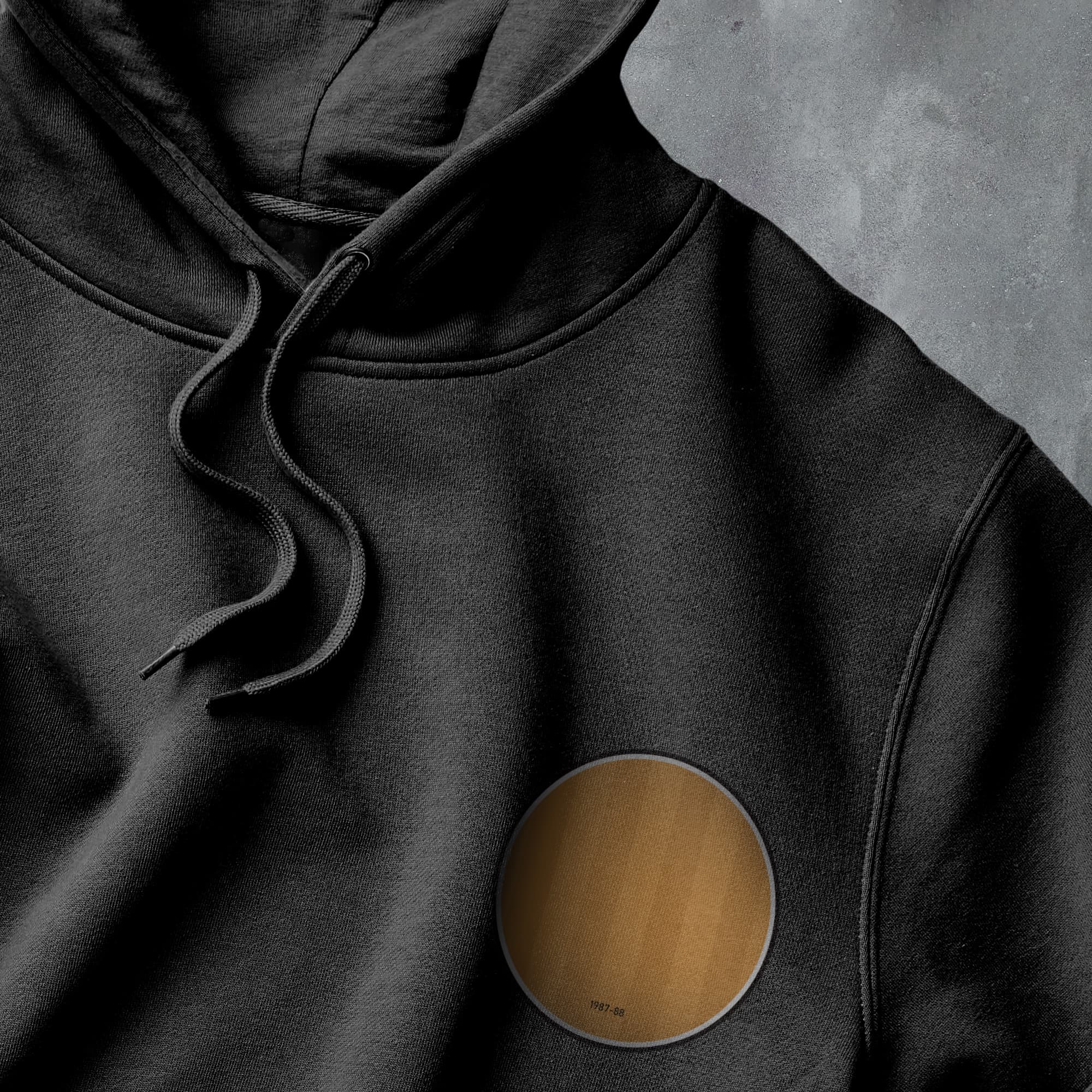a black hoodie with a gold circle on it