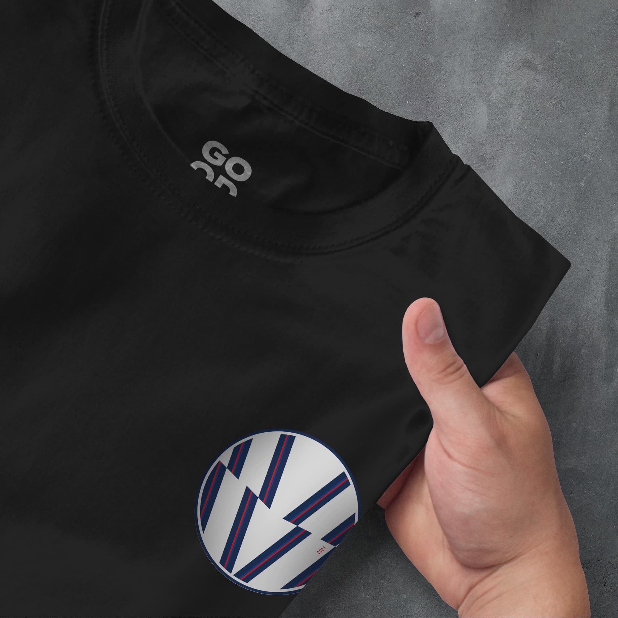 a person pointing at a black shirt with a white vw logo on it