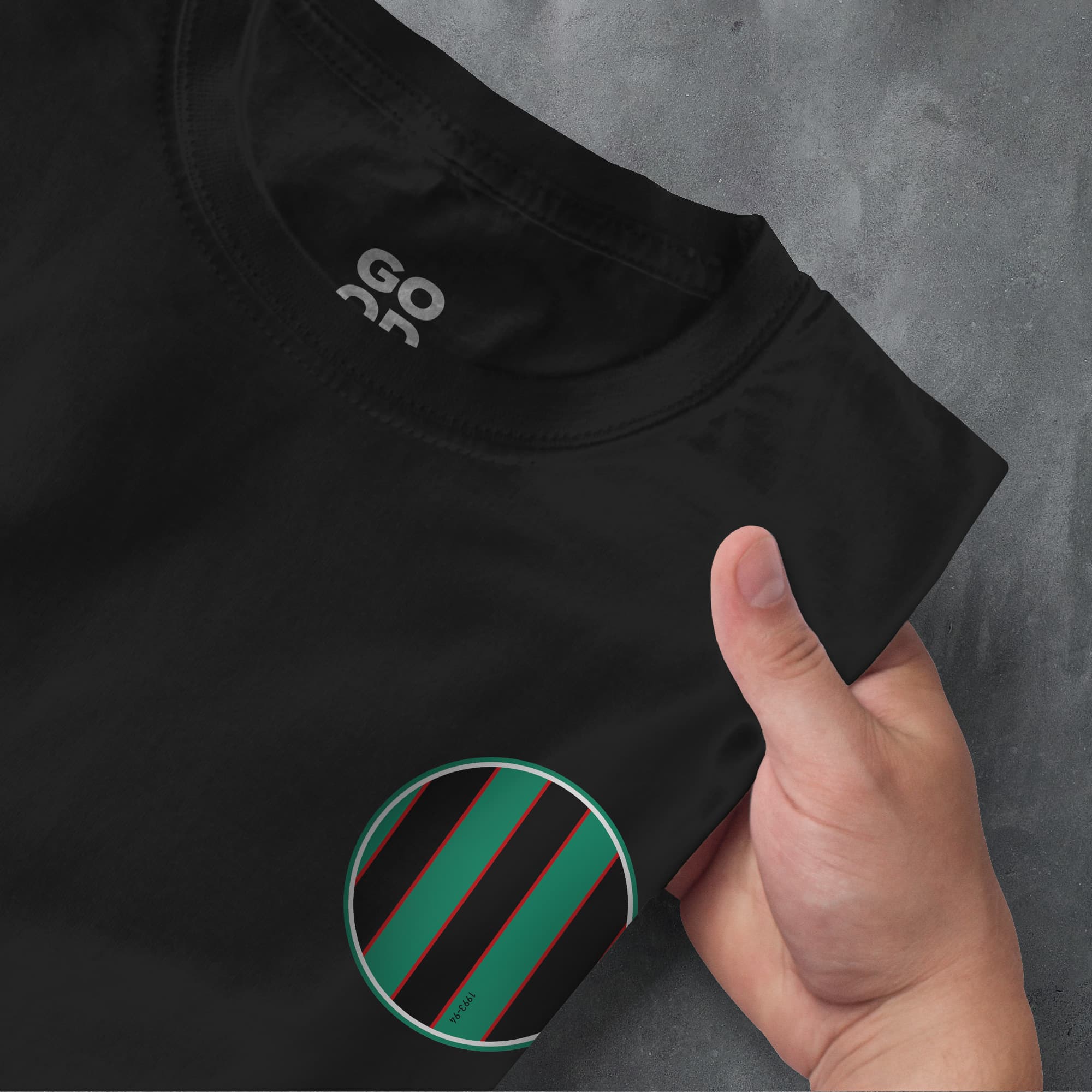 a hand pointing at a black shirt with green and black stripes