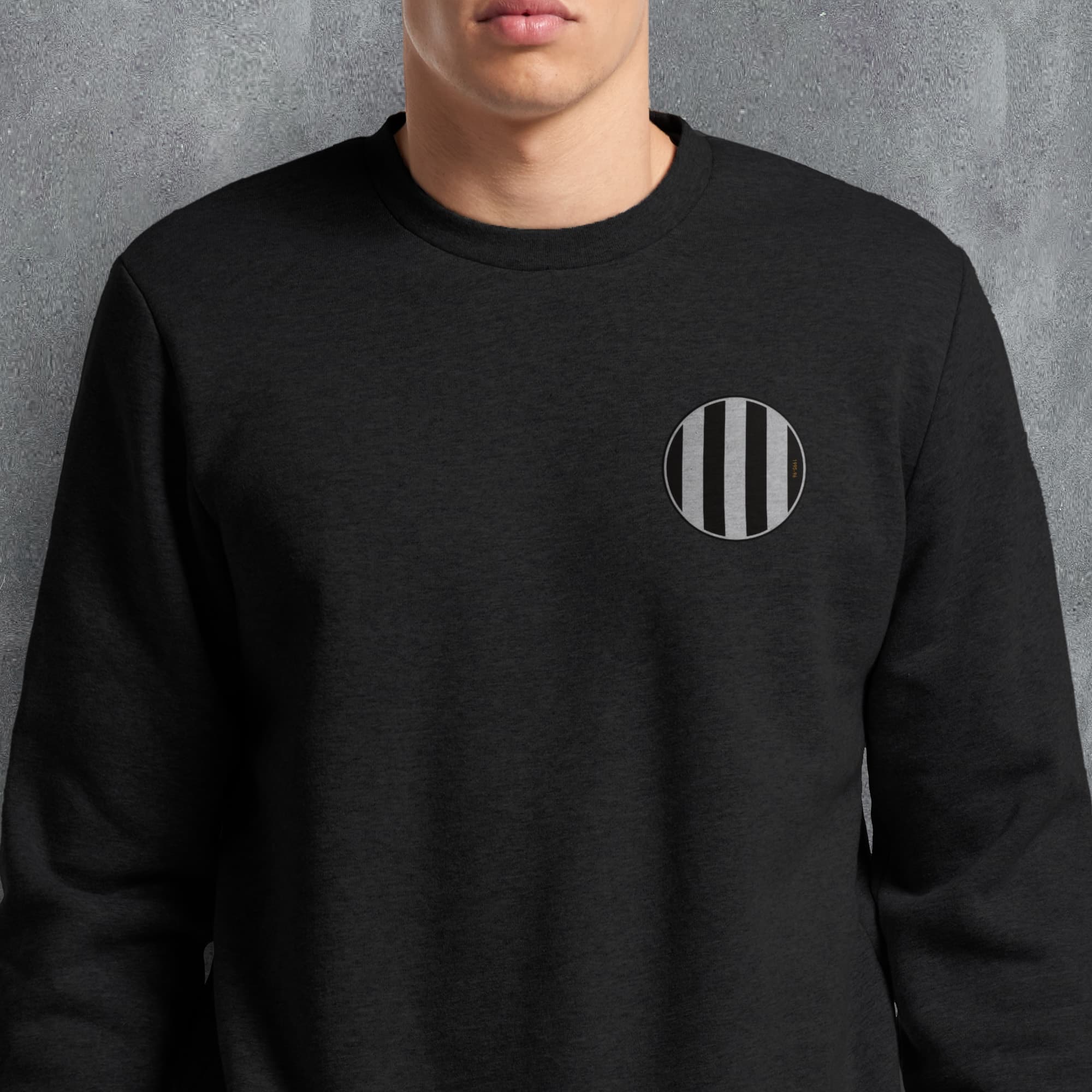 a man wearing a black sweatshirt with a black and white circle on it
