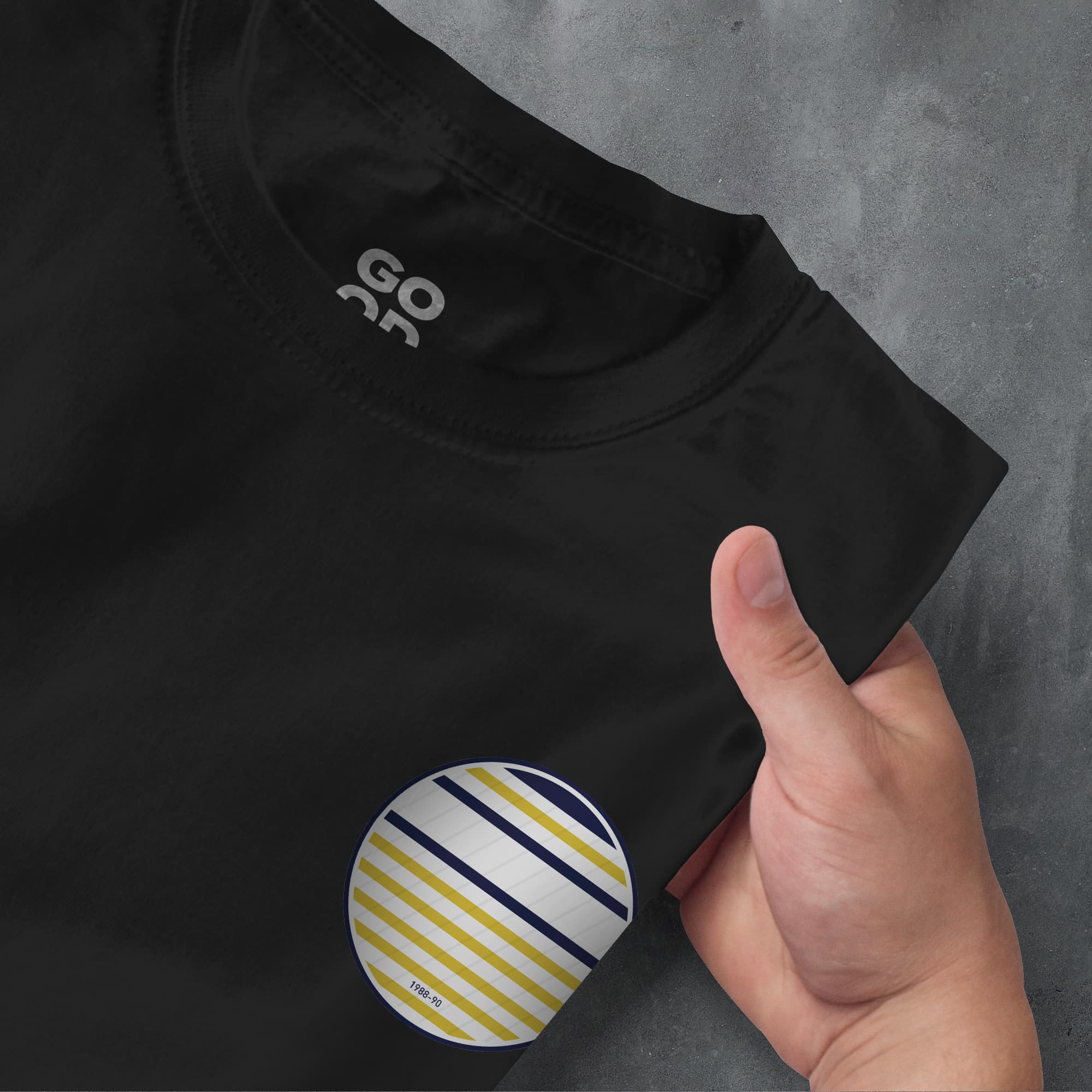 a person pointing at a black shirt with yellow and blue stripes