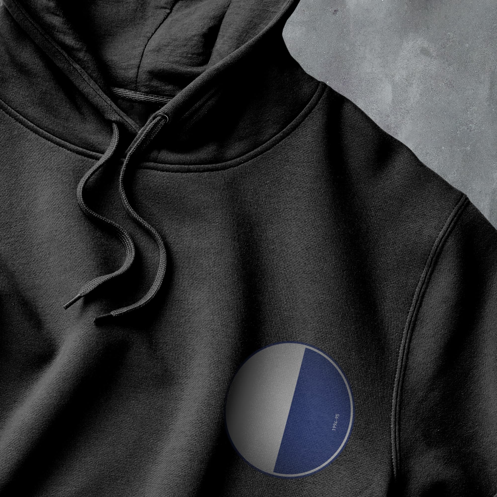 a black hoodie with a blue and white circle on it