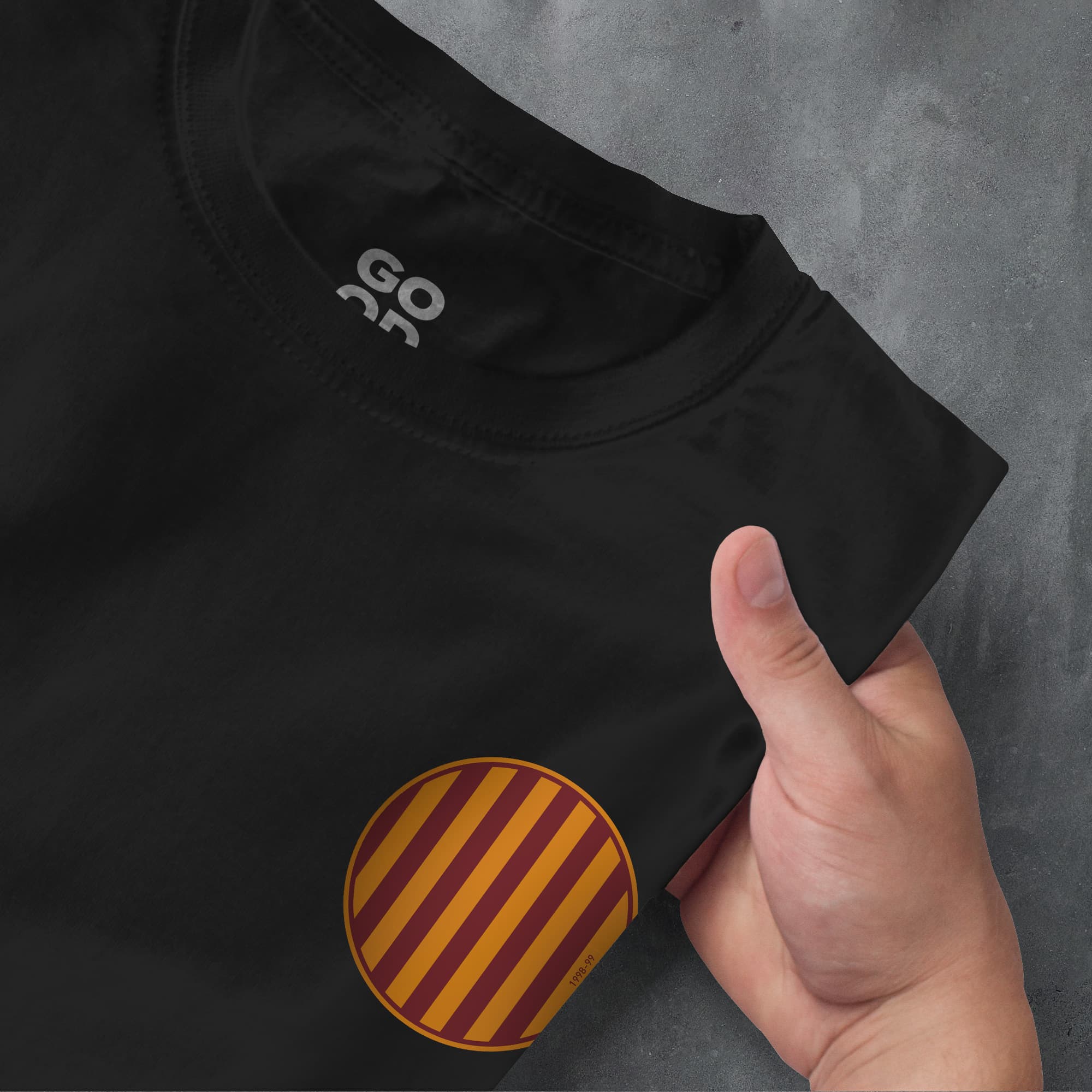 a hand pointing at a black shirt with a red and yellow stripe on it