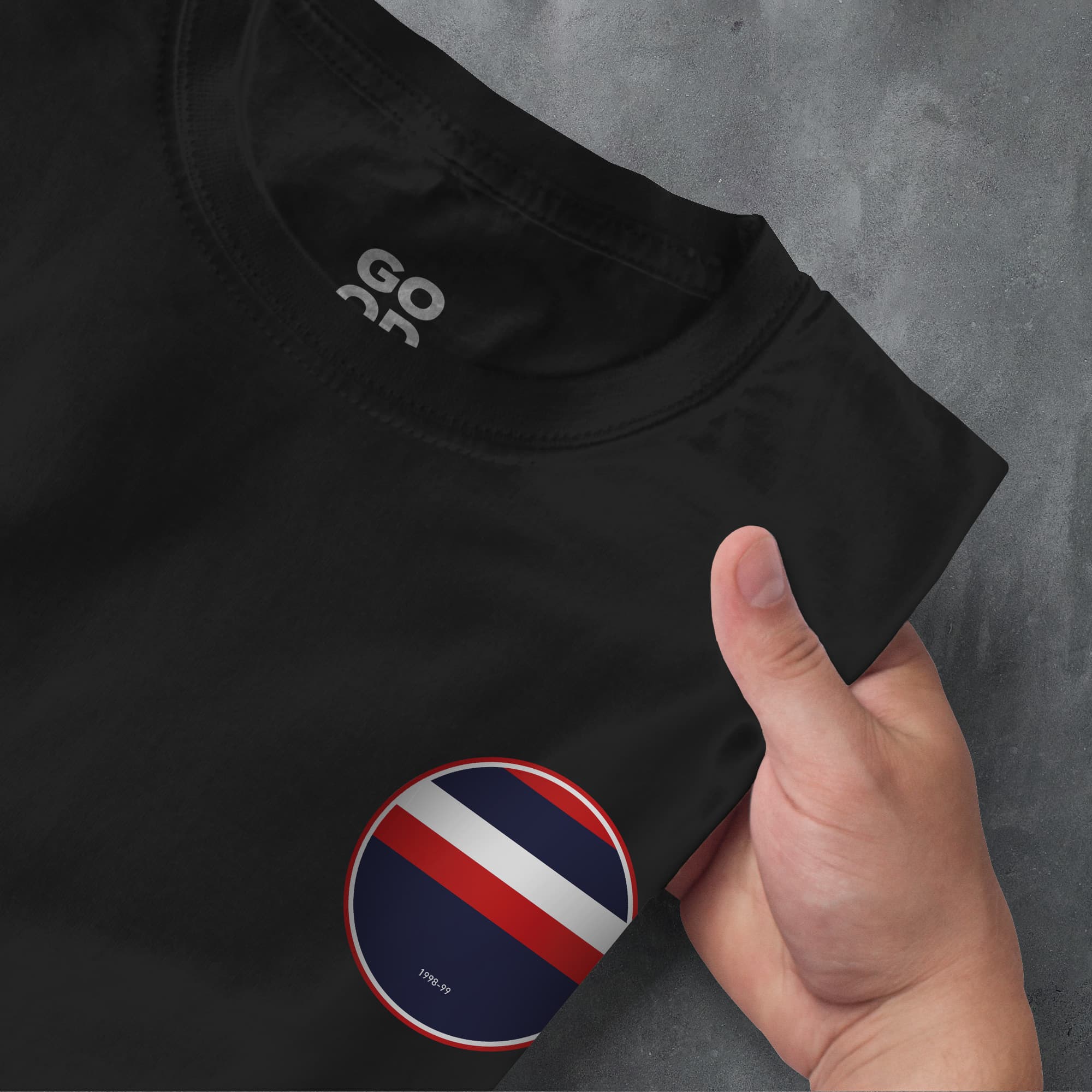 a hand pointing at a black shirt with a red, white, and blue stripe