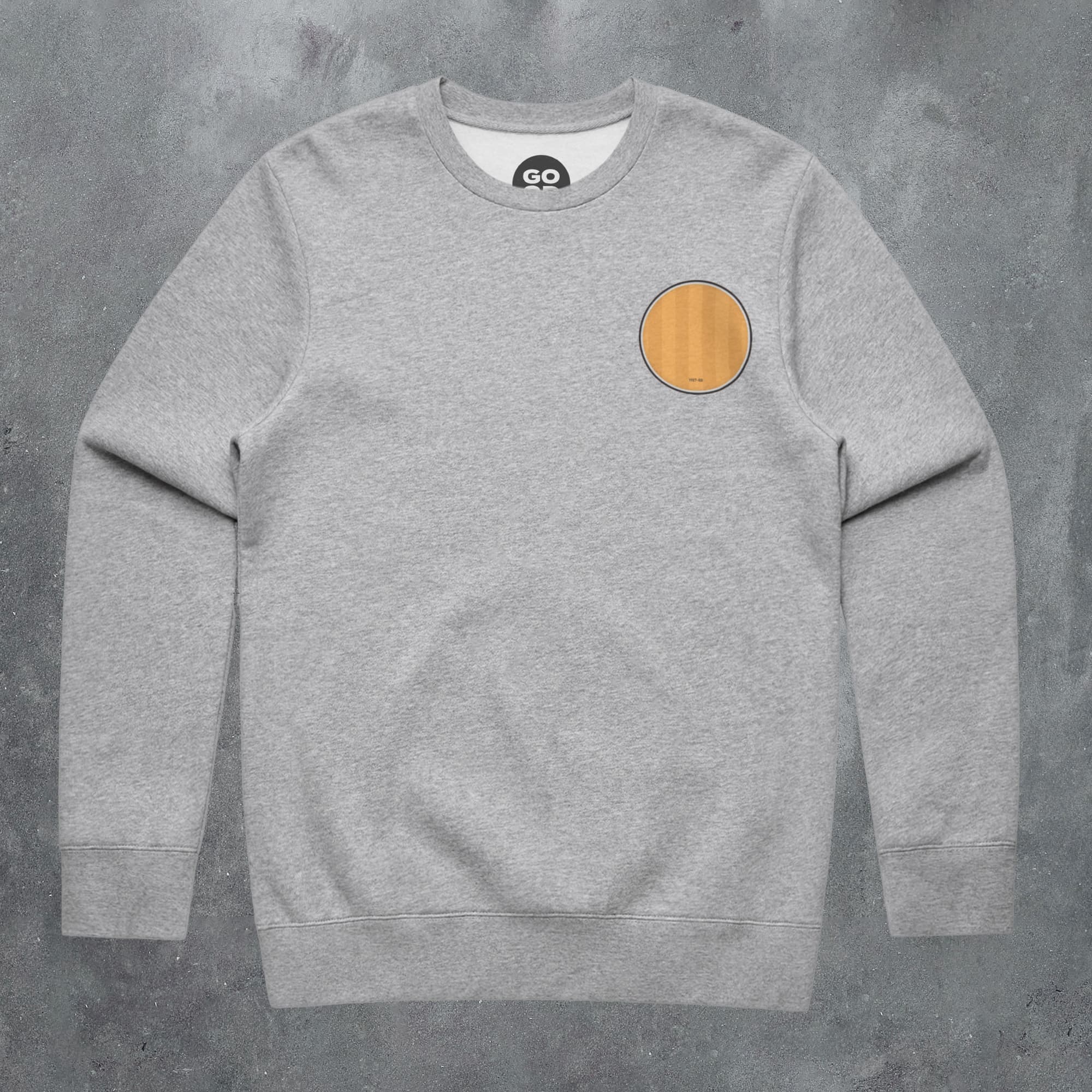 a grey sweatshirt with an orange patch on the chest