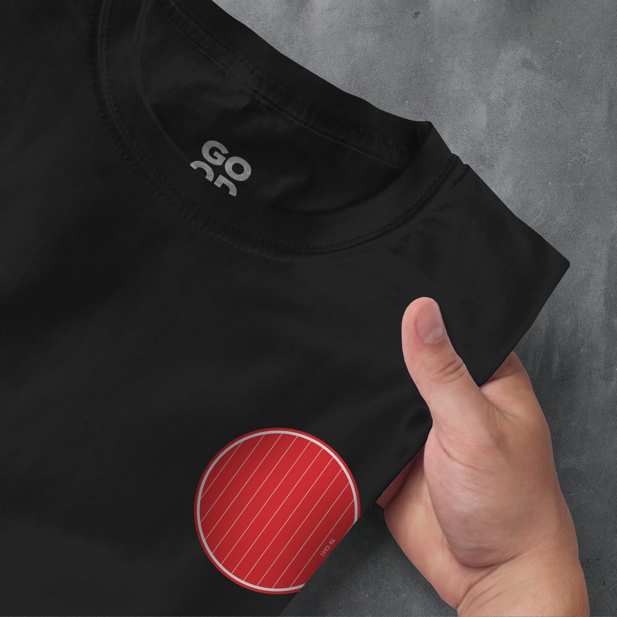 a person pointing at a black shirt with a red stripe on it