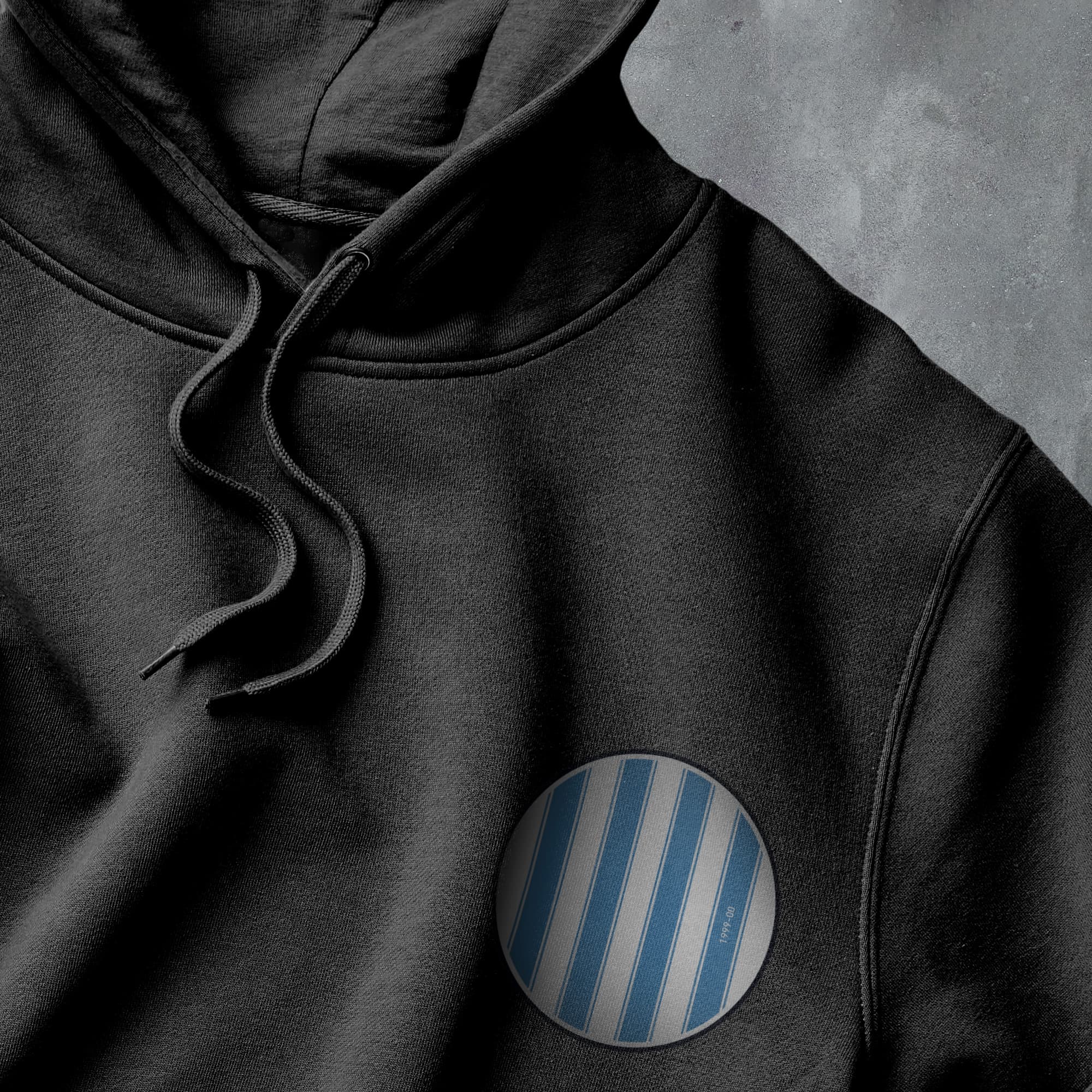 a close up of a black hoodie with a blue stripe on it