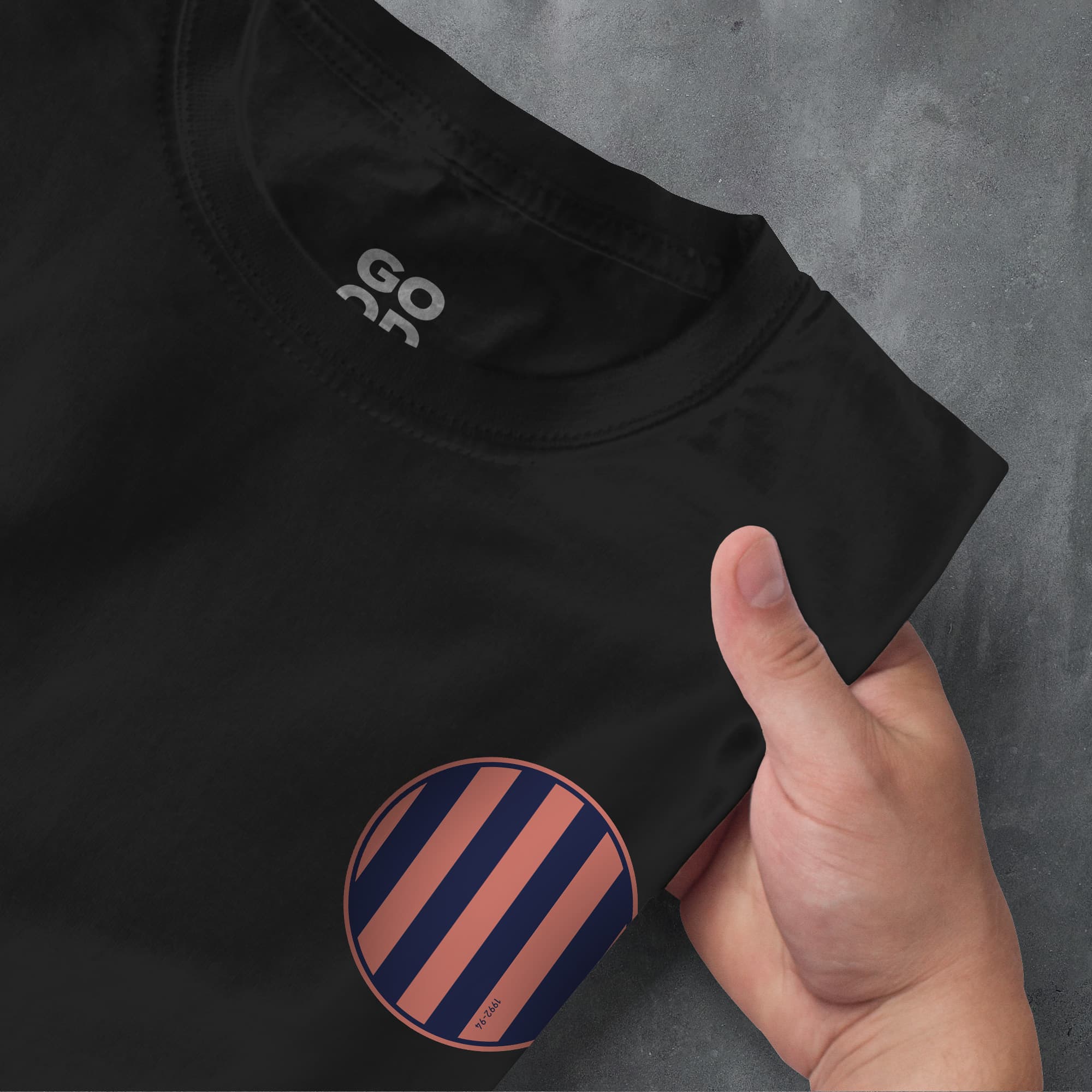 a person's hand pointing at a t - shirt with a sticker on