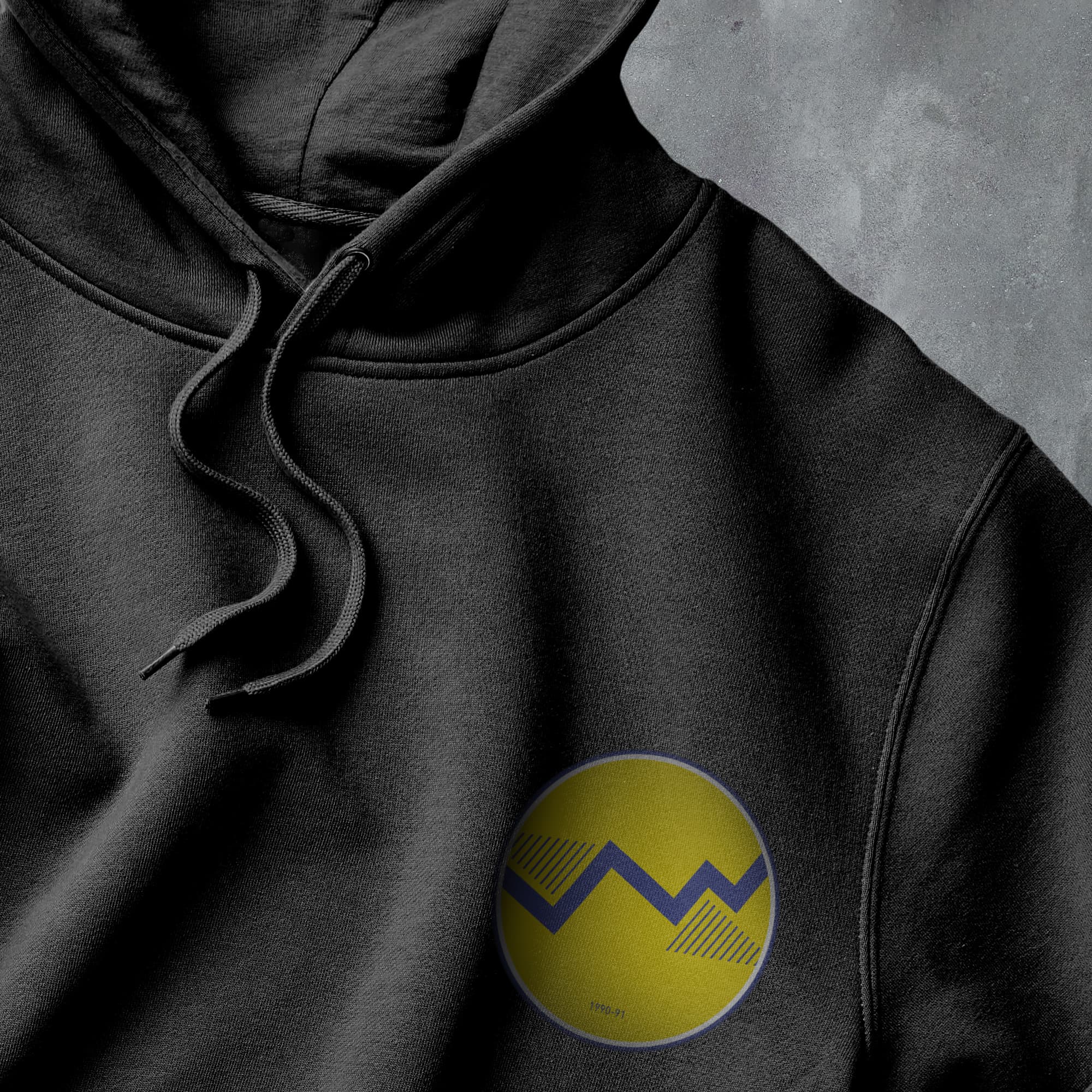 a close up of a black hoodie with a yellow smiley face on it