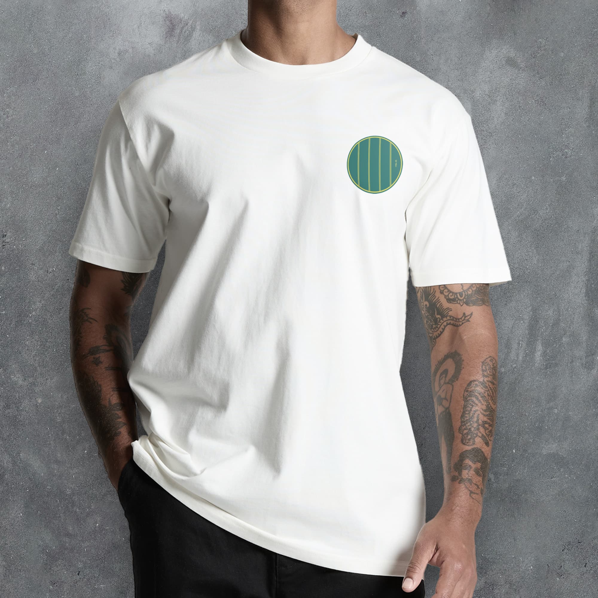 a man wearing a white t - shirt with a green circle on it