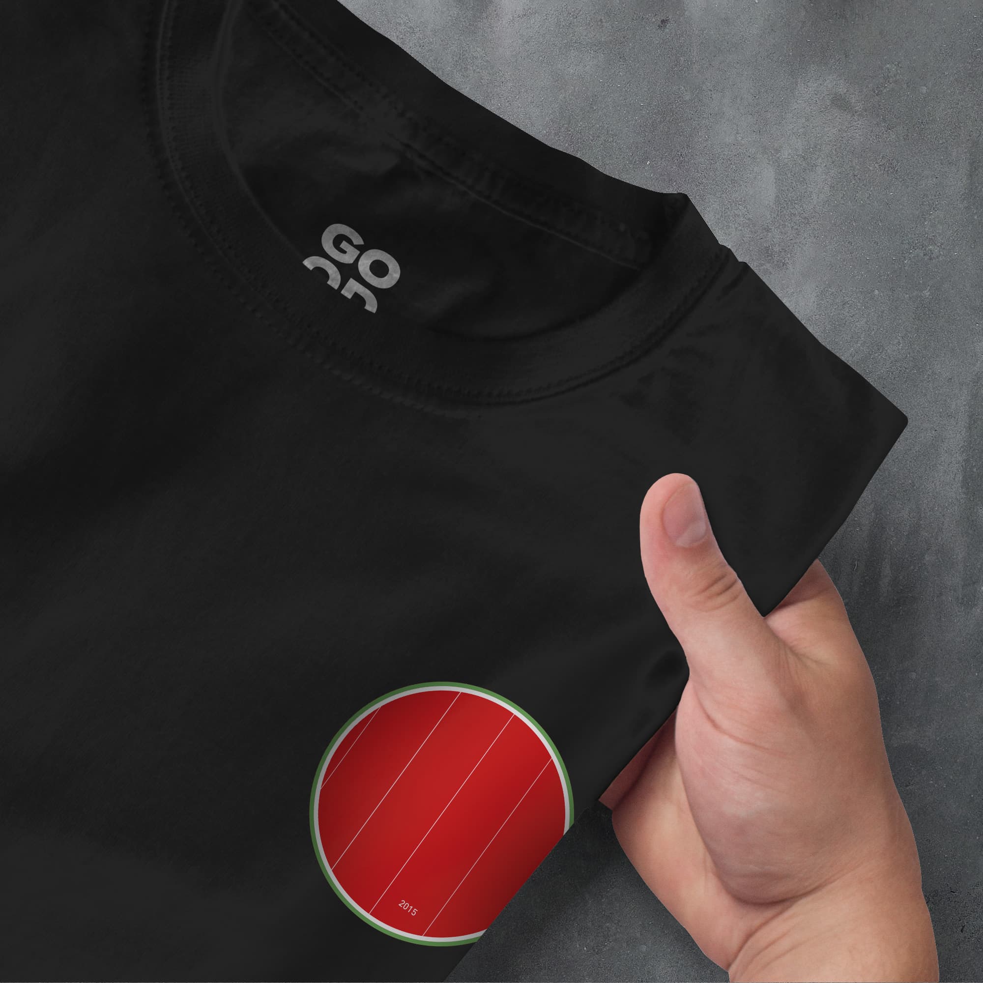 a hand pointing at a black shirt with a red circle on it