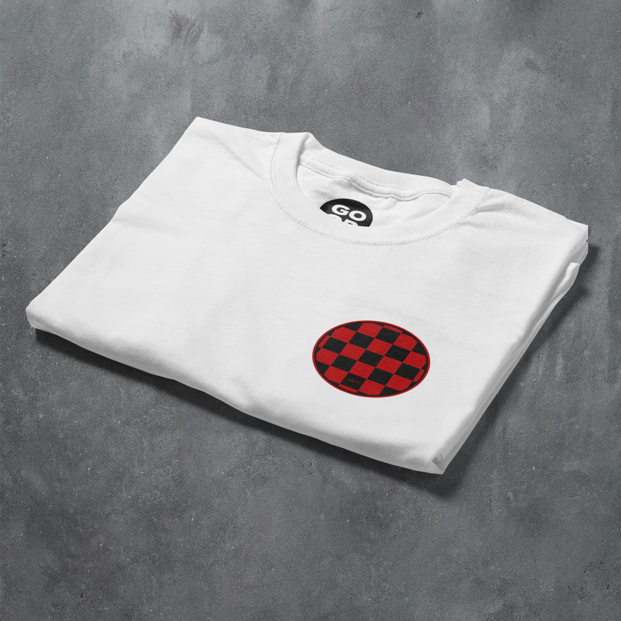 a white t - shirt with a red and black checkered design