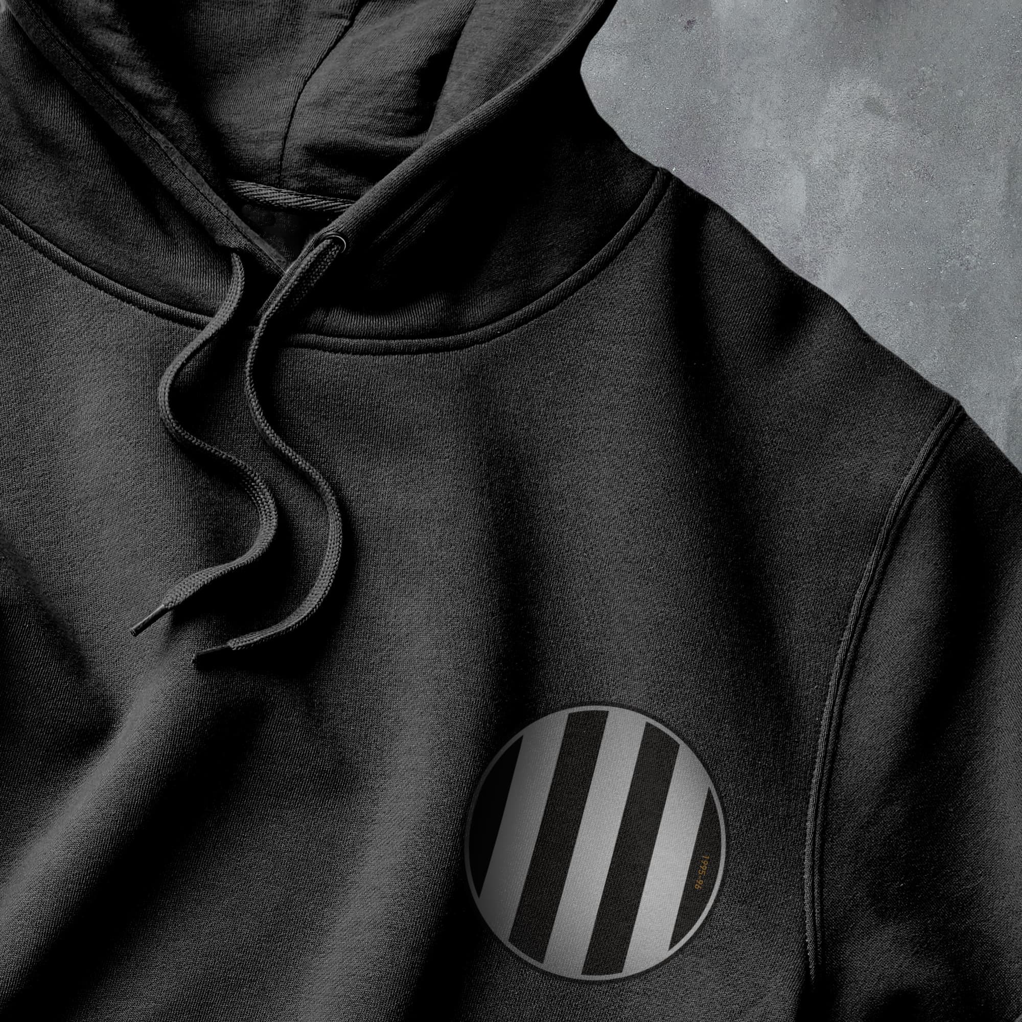 a close up of a black hoodie with a black and white stripe on the