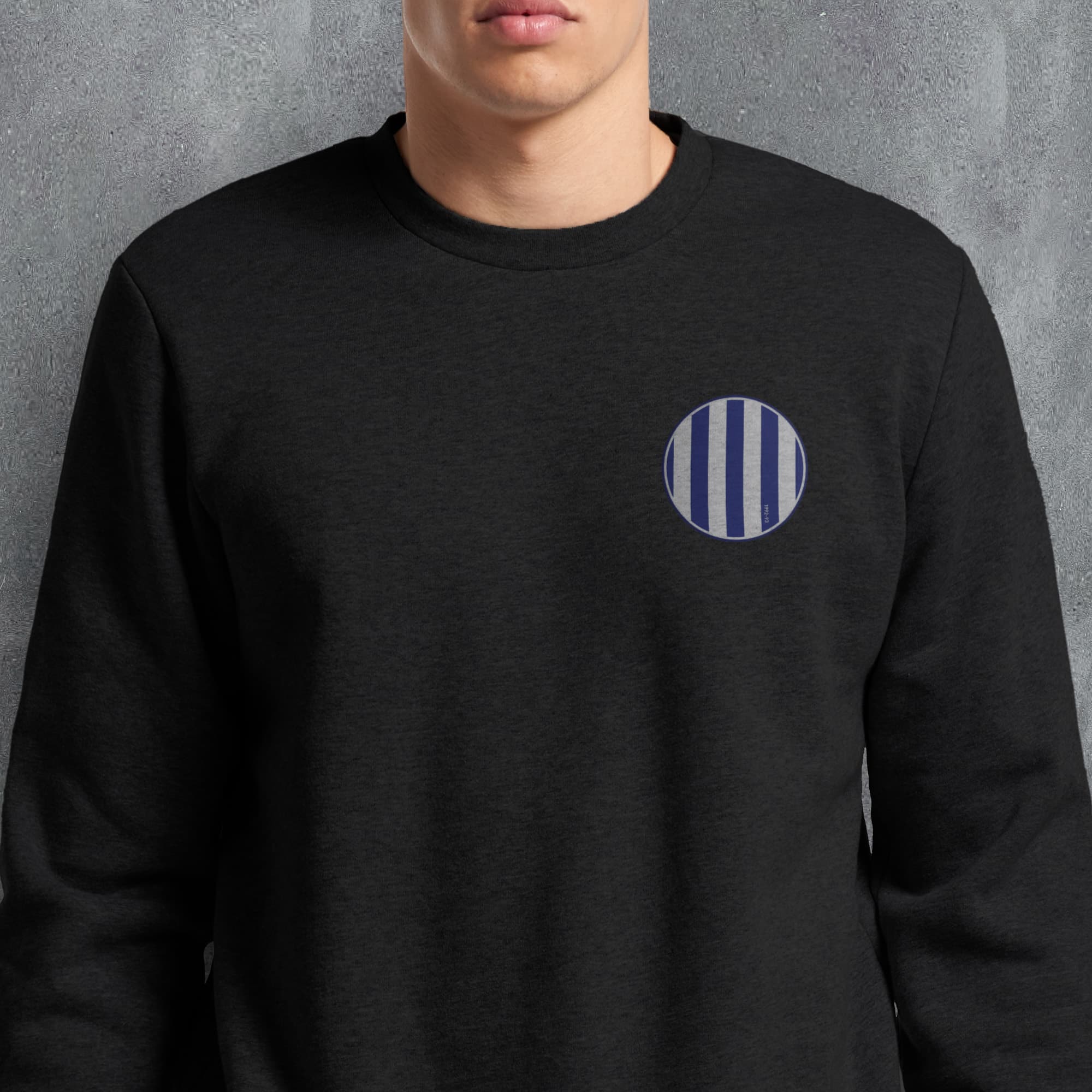 a man wearing a black sweatshirt with a blue and white circle on it