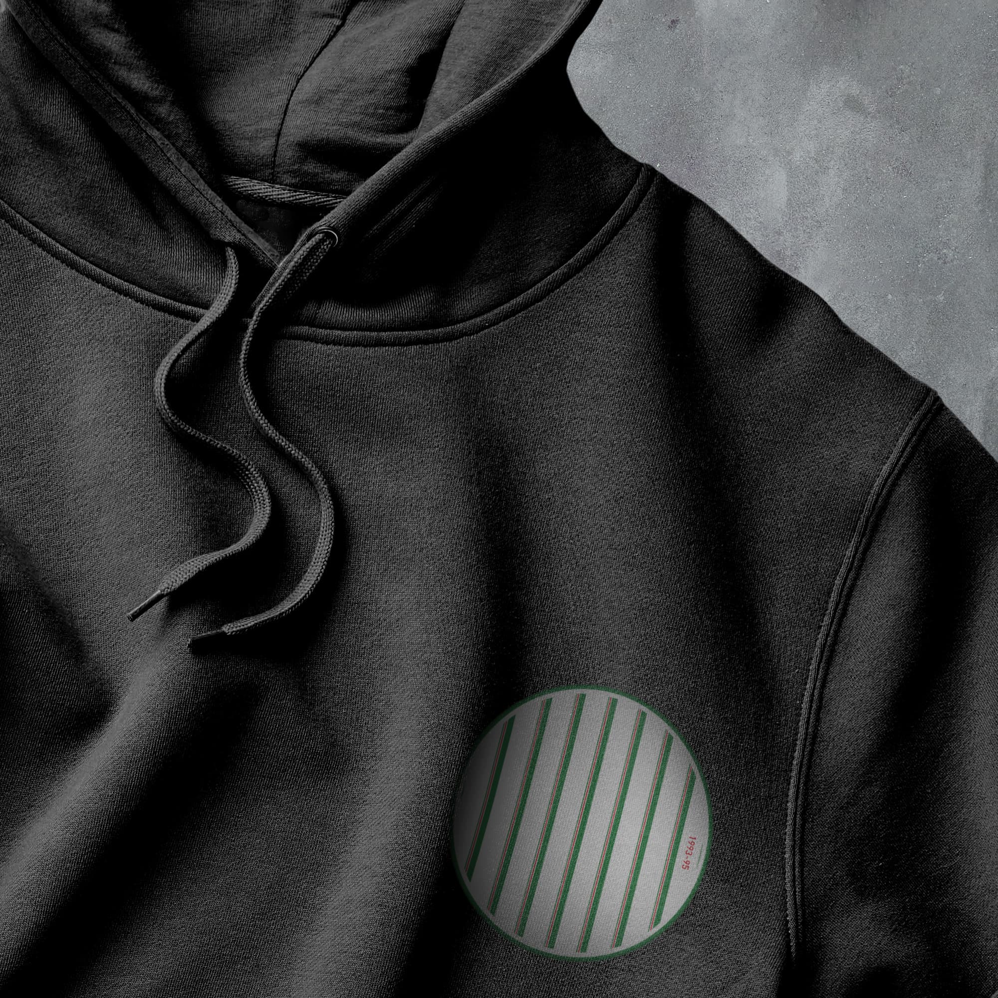 a close up of a black hoodie with a green circle on it
