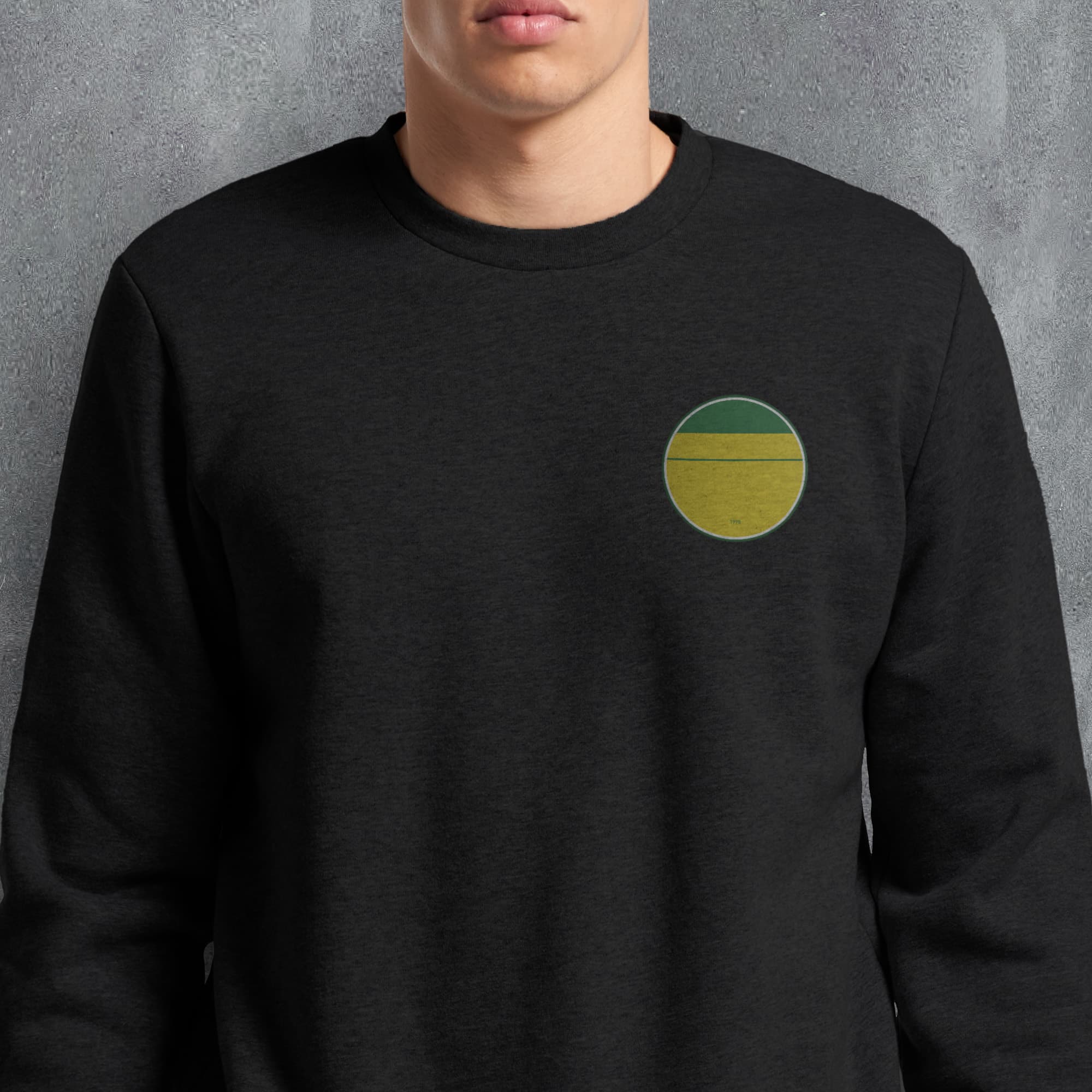 a man wearing a black sweatshirt with a green and yellow circle on it