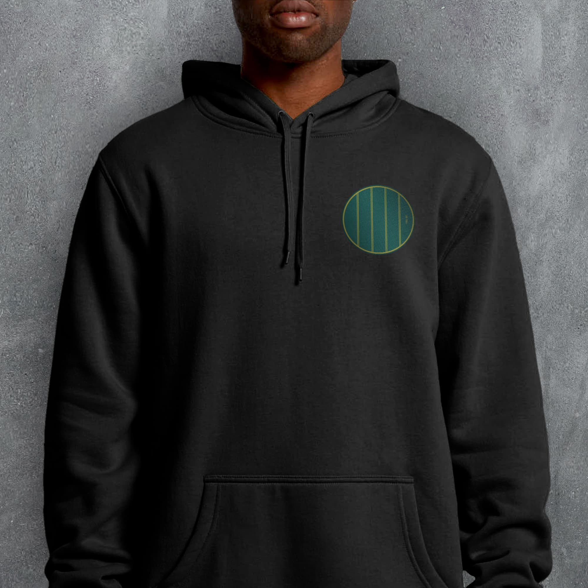 a man wearing a black hoodie with a green circle on it