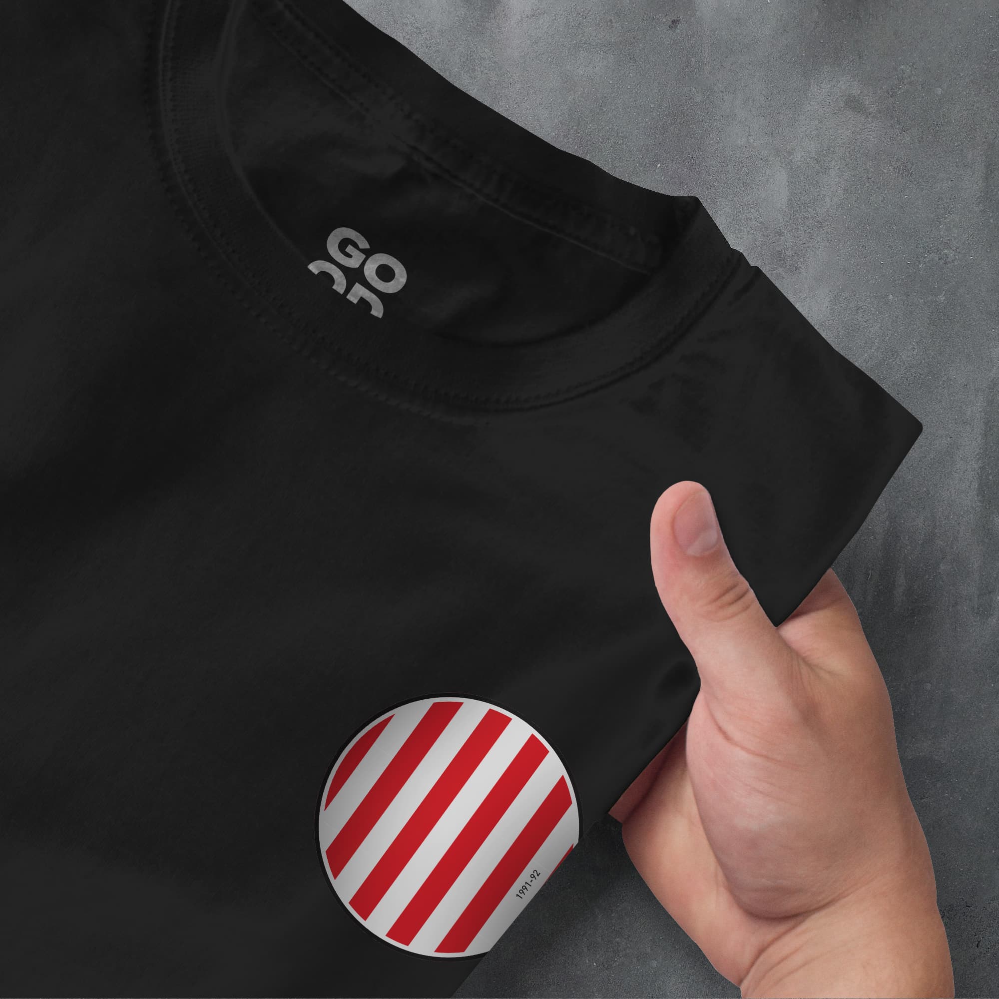 a person holding a red and white striped sticker on a black shirt
