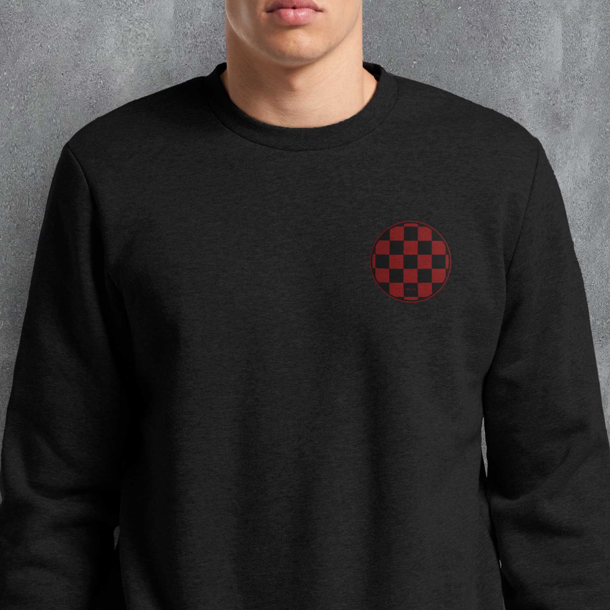 a man wearing a black sweatshirt with a red checkered pocket