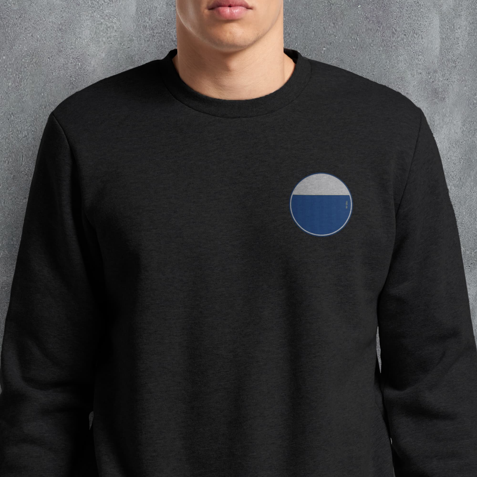 a man wearing a black sweatshirt with a blue circle on it