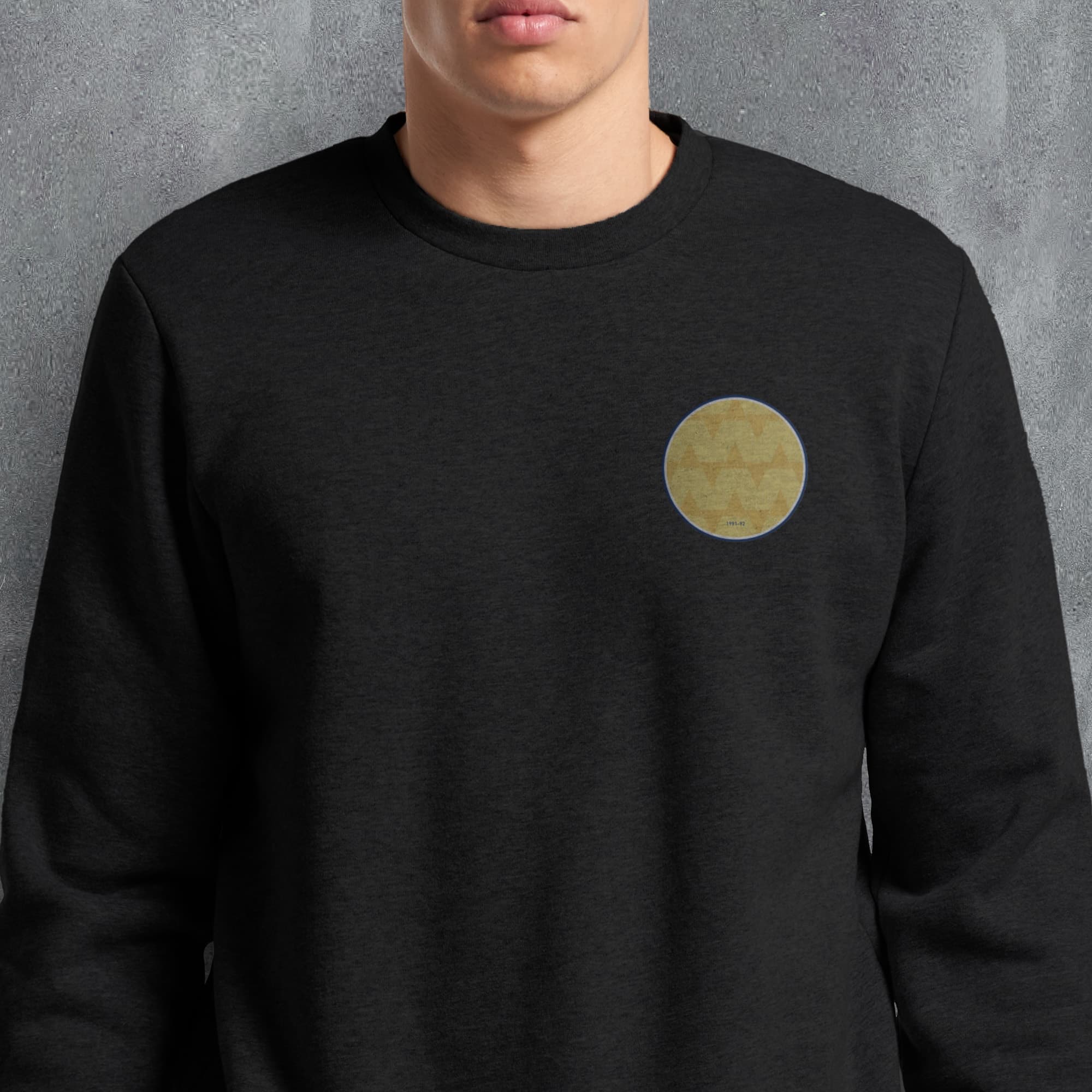 a man wearing a black sweatshirt with a yellow circle on it