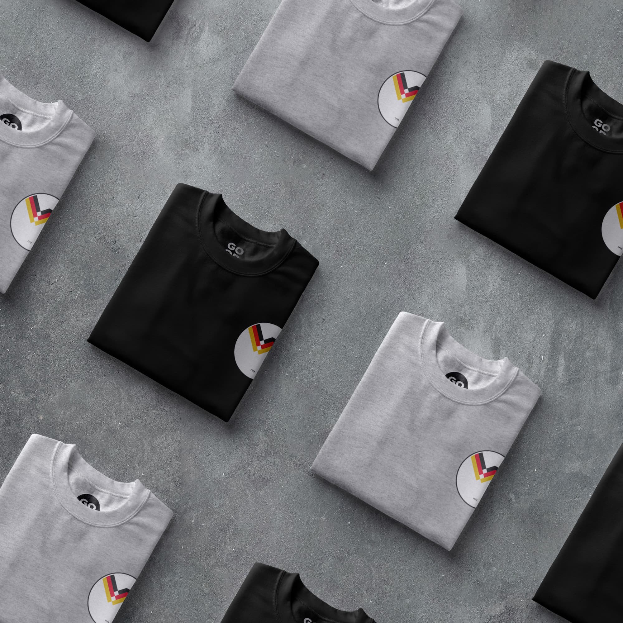 a group of black and white t - shirts on a gray surface