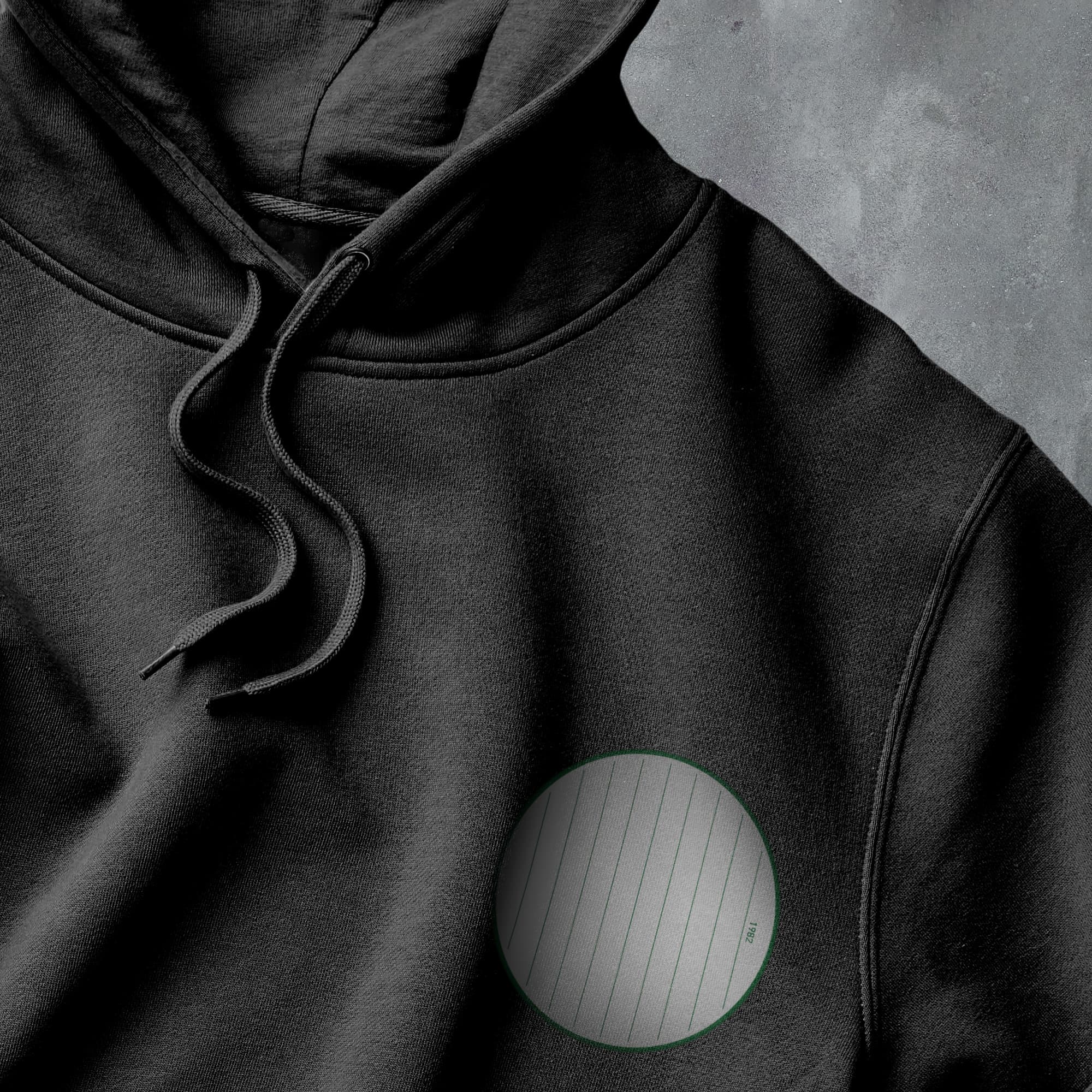 a black hoodie with a green circle on it