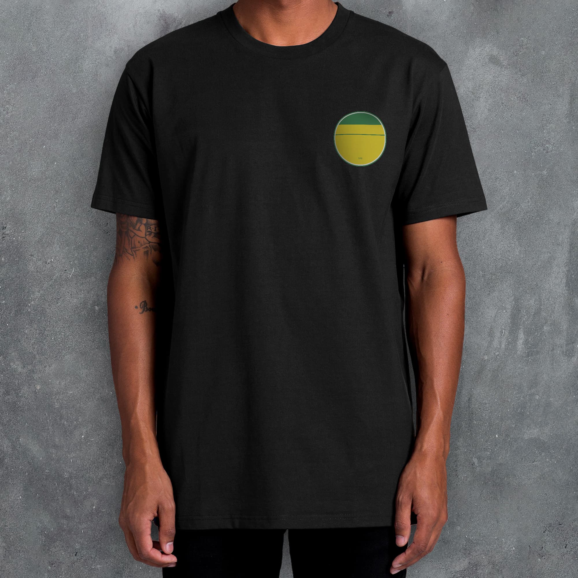a man wearing a black t - shirt with a yellow and green circle on the