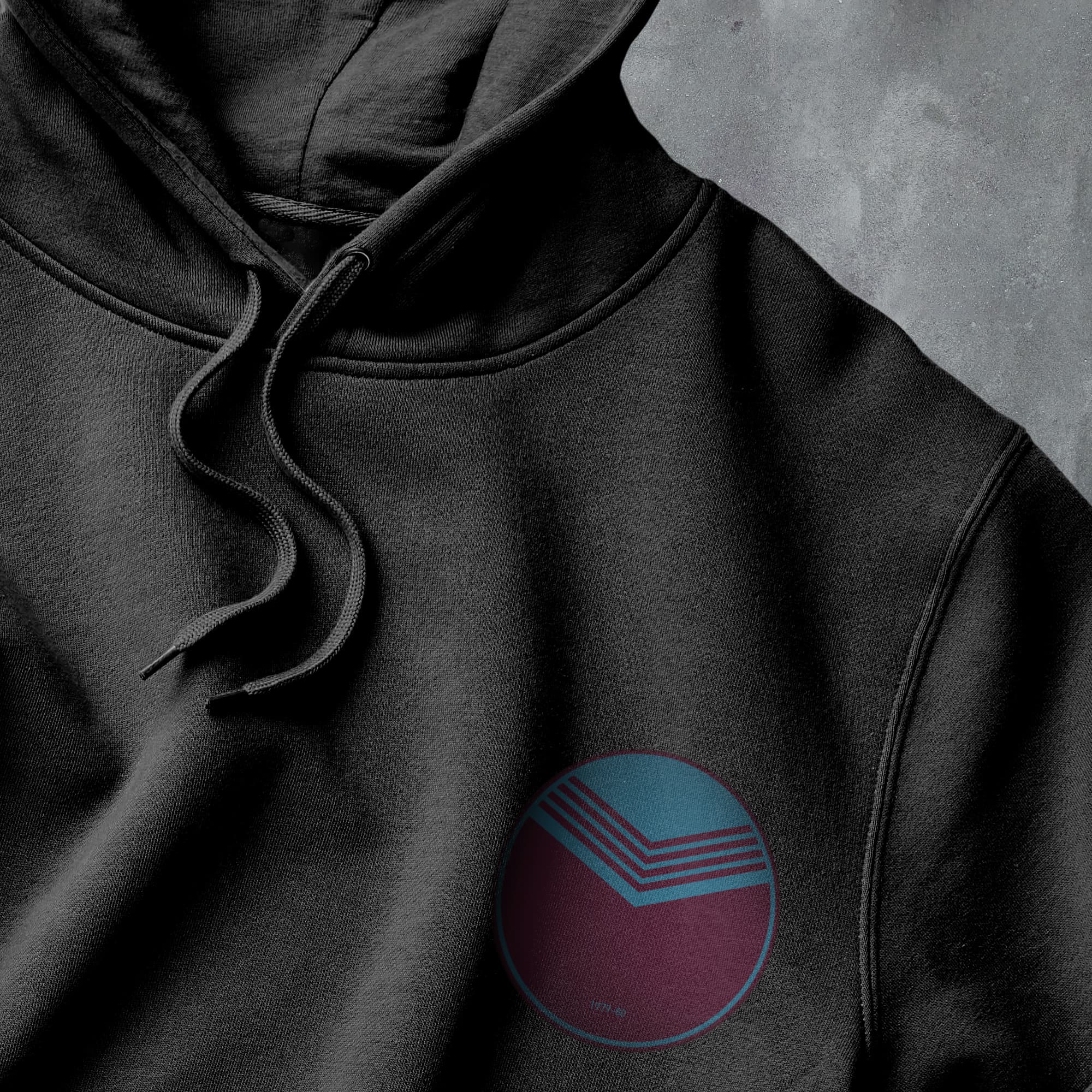 a close up of a black hoodie with a blue and red circle on it