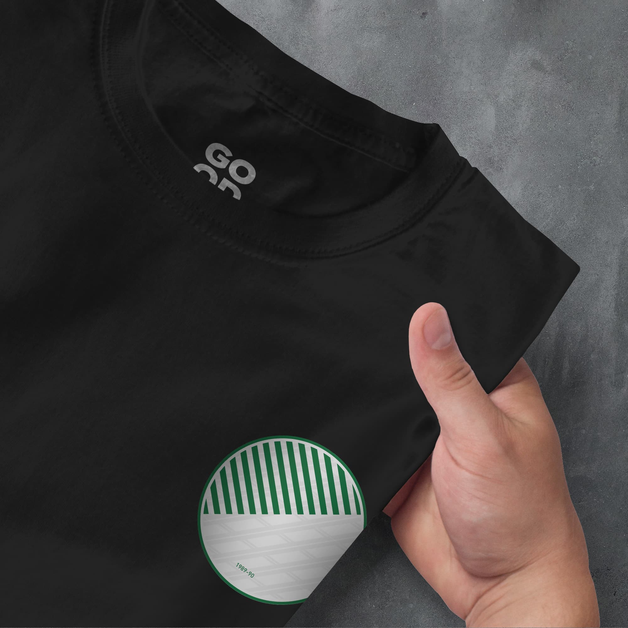 a person pointing at a black shirt with a green and white design on it