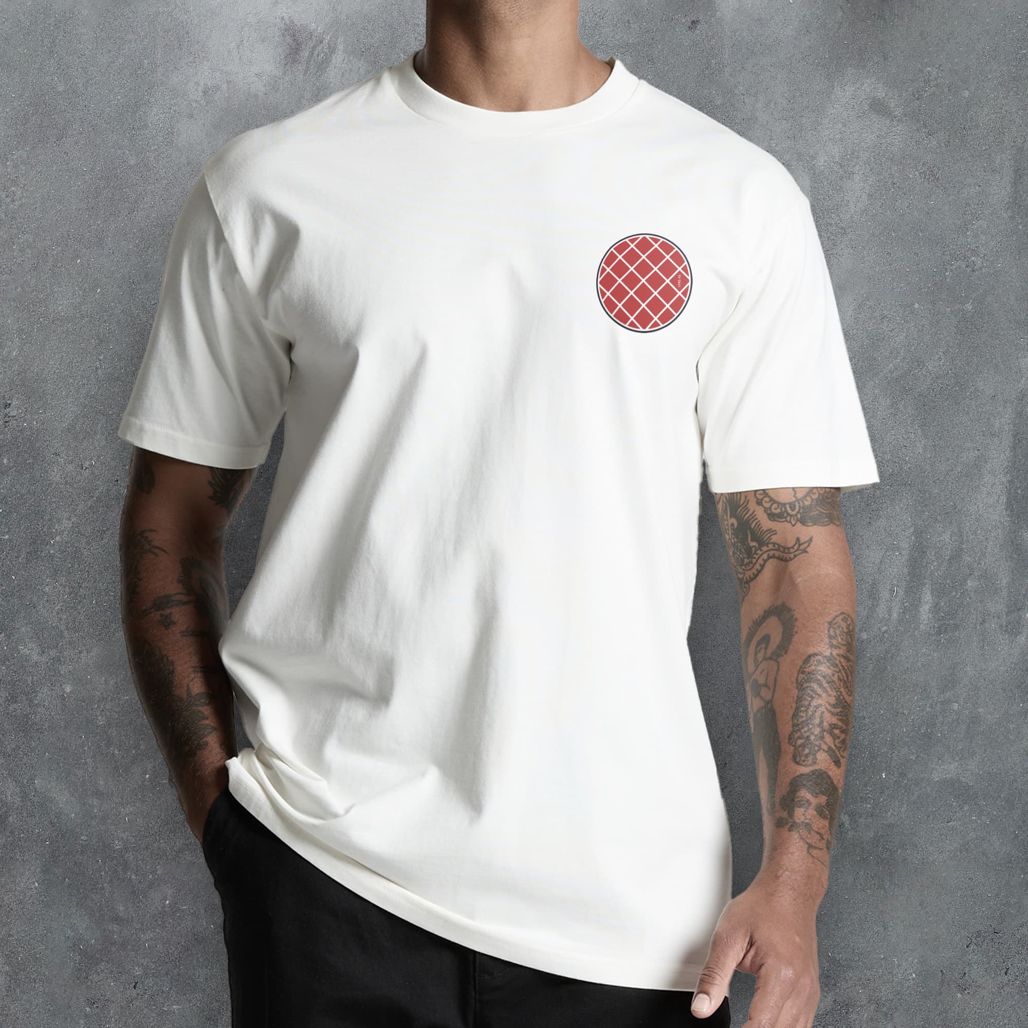 a man wearing a white t - shirt with a red checkered circle on the