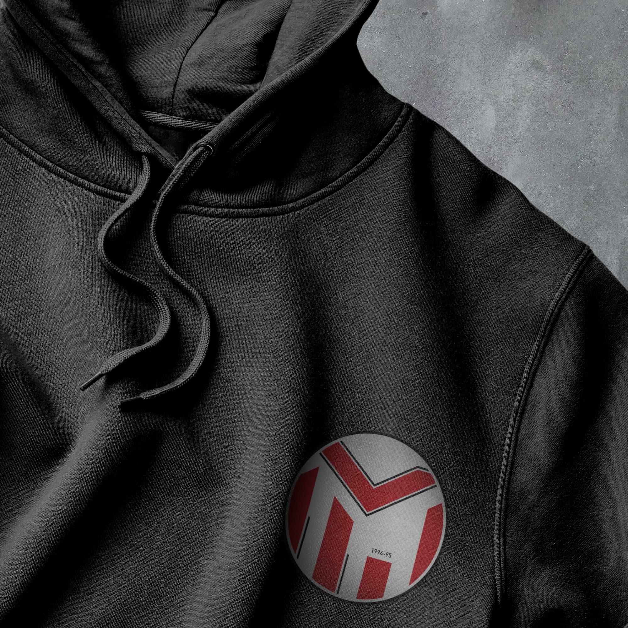 a close up of a black hoodie with a red and white logo