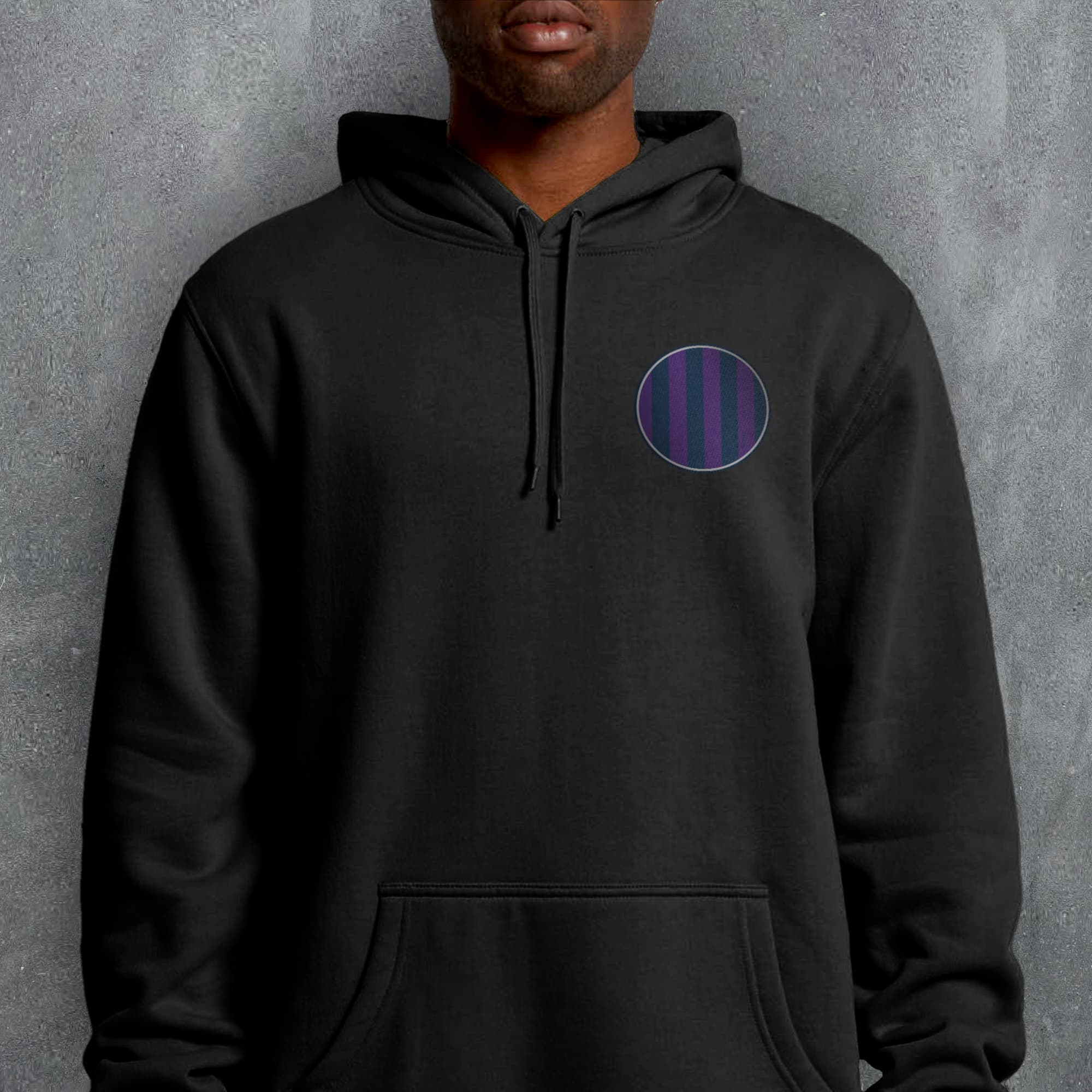 a man wearing a black hoodie with a purple circle on it